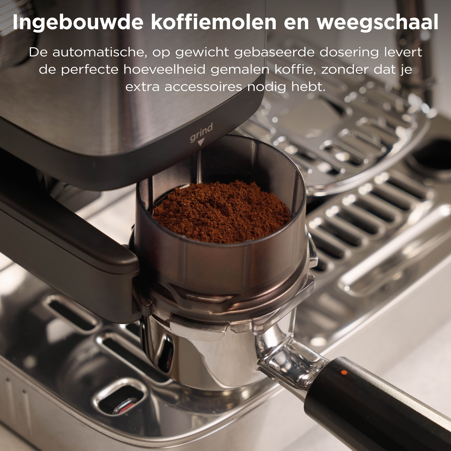 A portafilter filled with freshly ground coffee sits under an espresso machine grinder.