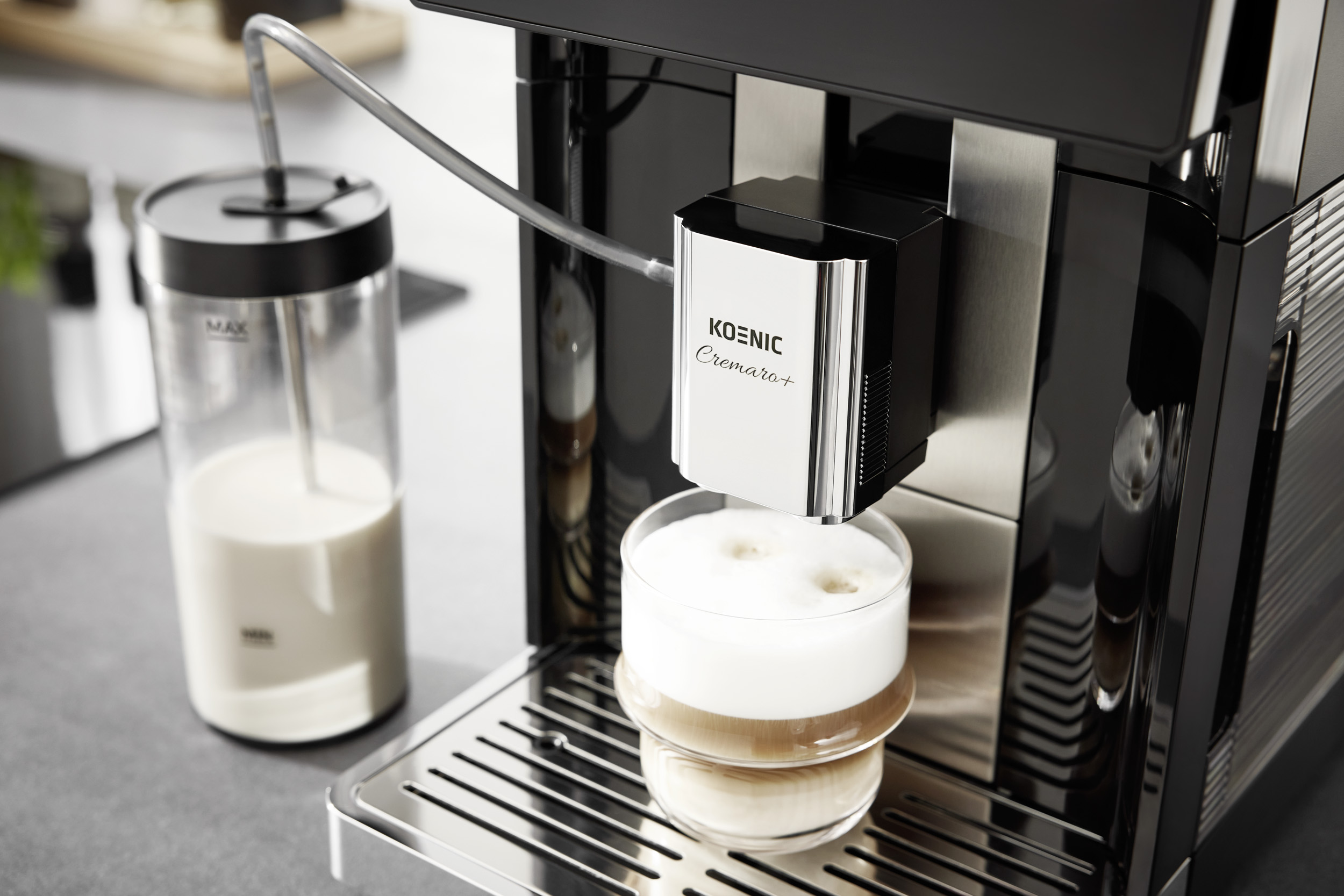 Moderne Kaffeemaschine mit Milchbehälter bereitet Latte Macchiato in einem Glas zu.
