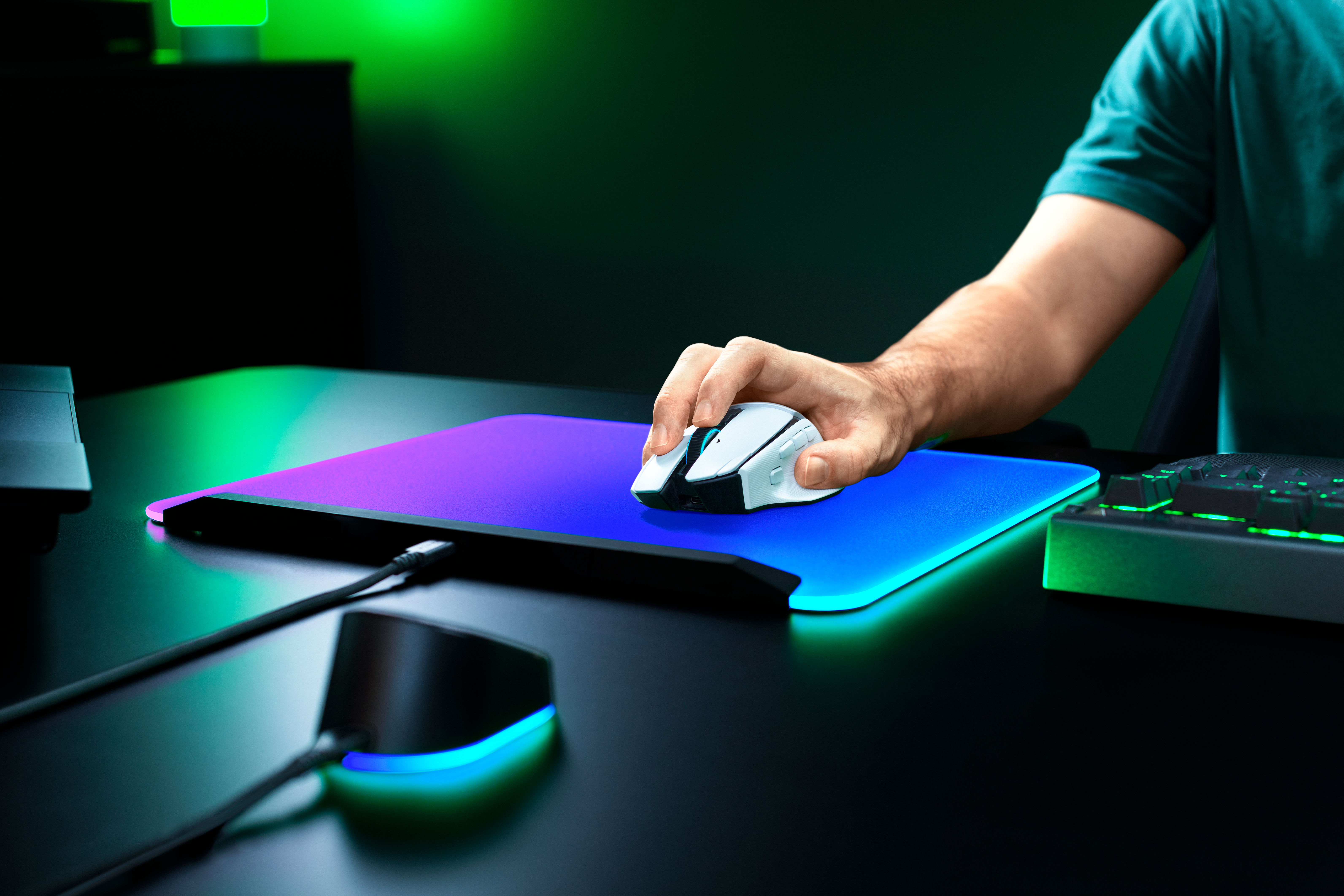 Eine Person benutzt eine weiße Gaming-Maus auf einem leuchtend blauen und lila RGB-Mauspad.
