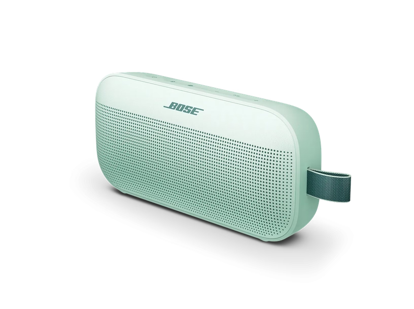 Ein hellgrüner Bose Bluetooth-Lautsprecher mit Trageschlaufe vor schwarzem Hintergrund.