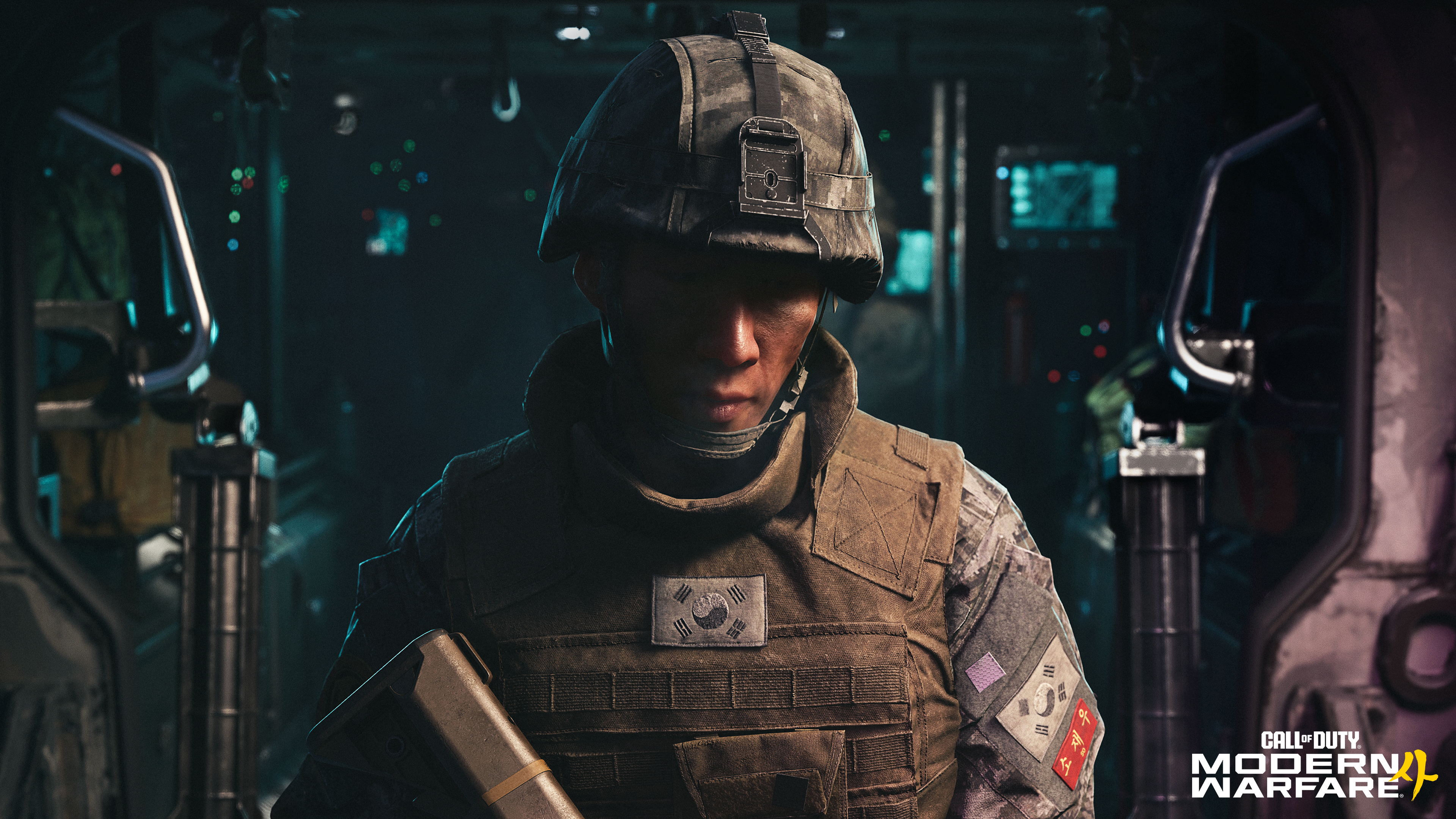 Soldat mit Helm und Weste, verziert mit südkoreanischen Flaggen, steht im dimm-beleuchteten Inneren eines Fahrzeugs.