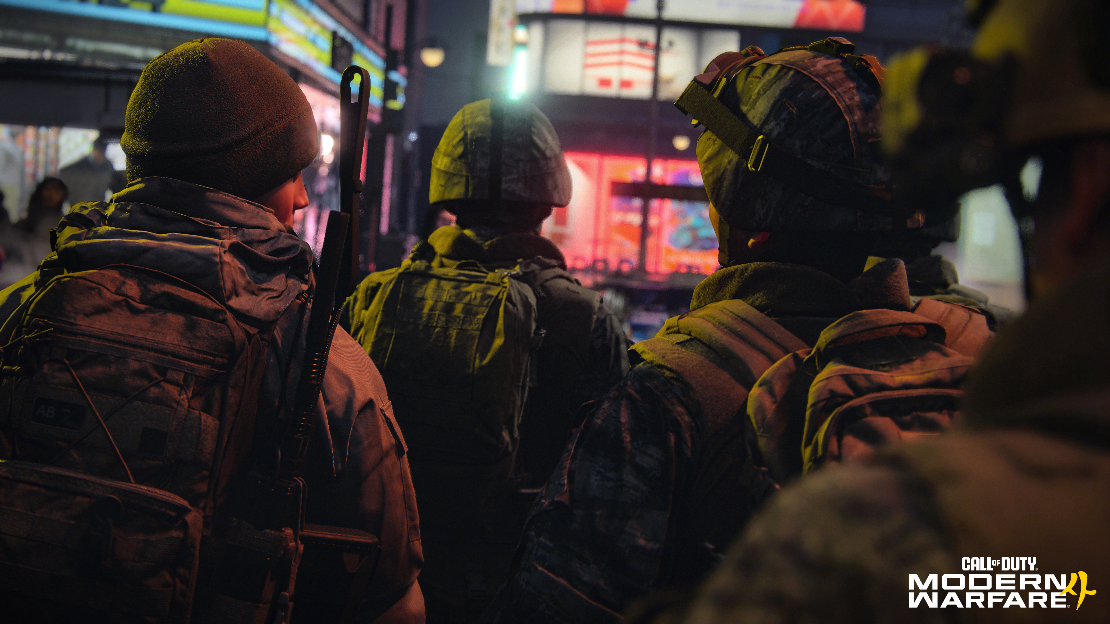 Vier Soldaten mit Rucksäcken und Helmen blicken in eine beleuchtete Stadt bei Nacht.