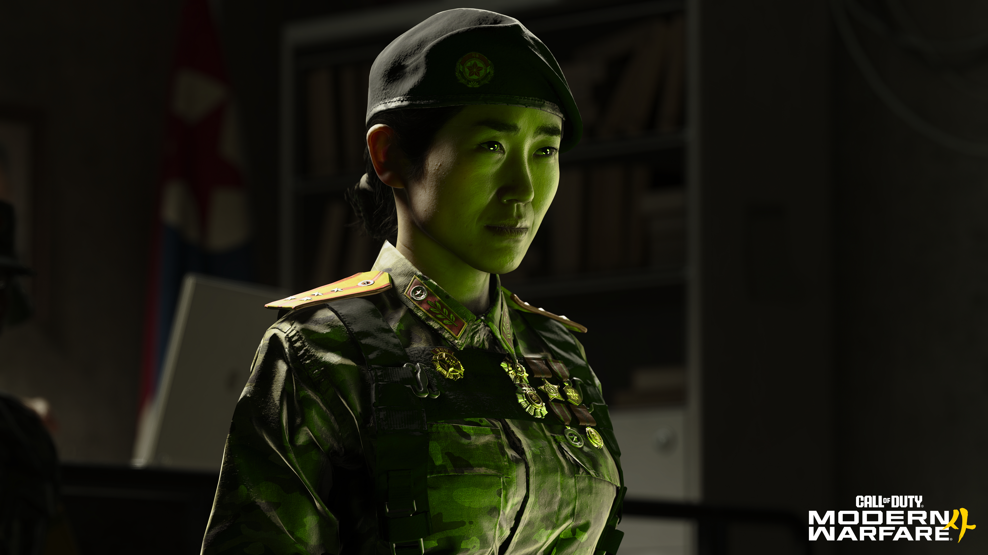 Eine Frau in Militäruniform und mit Baskenmütze im grünen Licht.