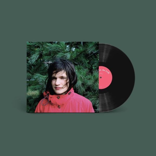 Eine Vinyl-Schallplatte und ein Cover mit einer Person in einer roten Jacke vor grünen Zweigen.