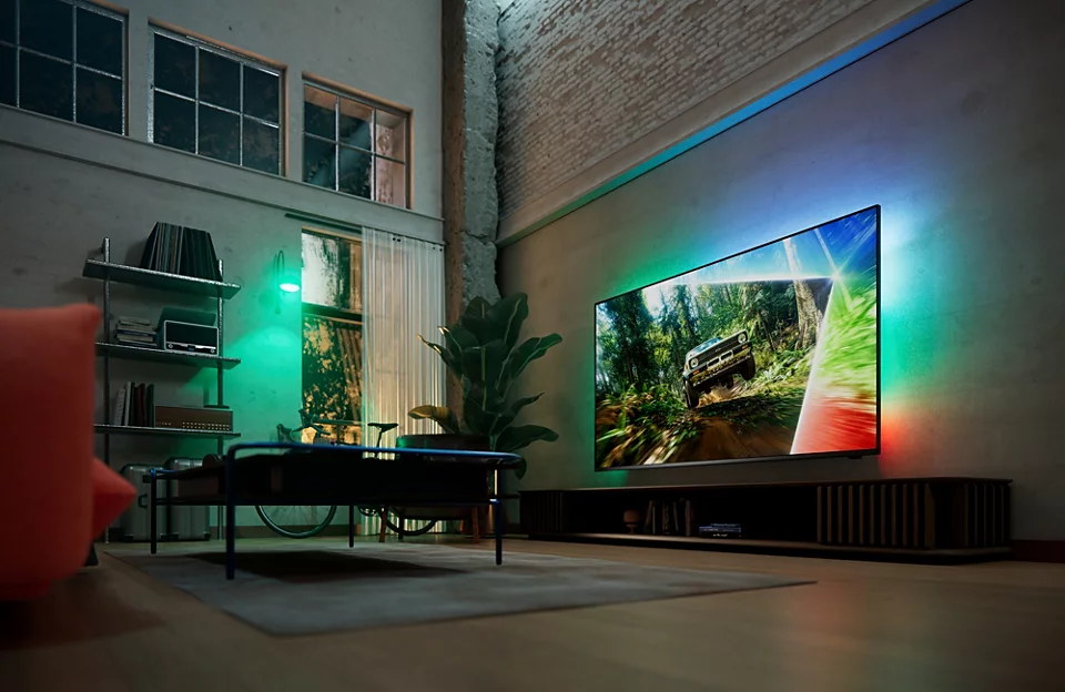 Wohnzimmer mit großer Fernseher und bunter Hintergrundbeleuchtung.