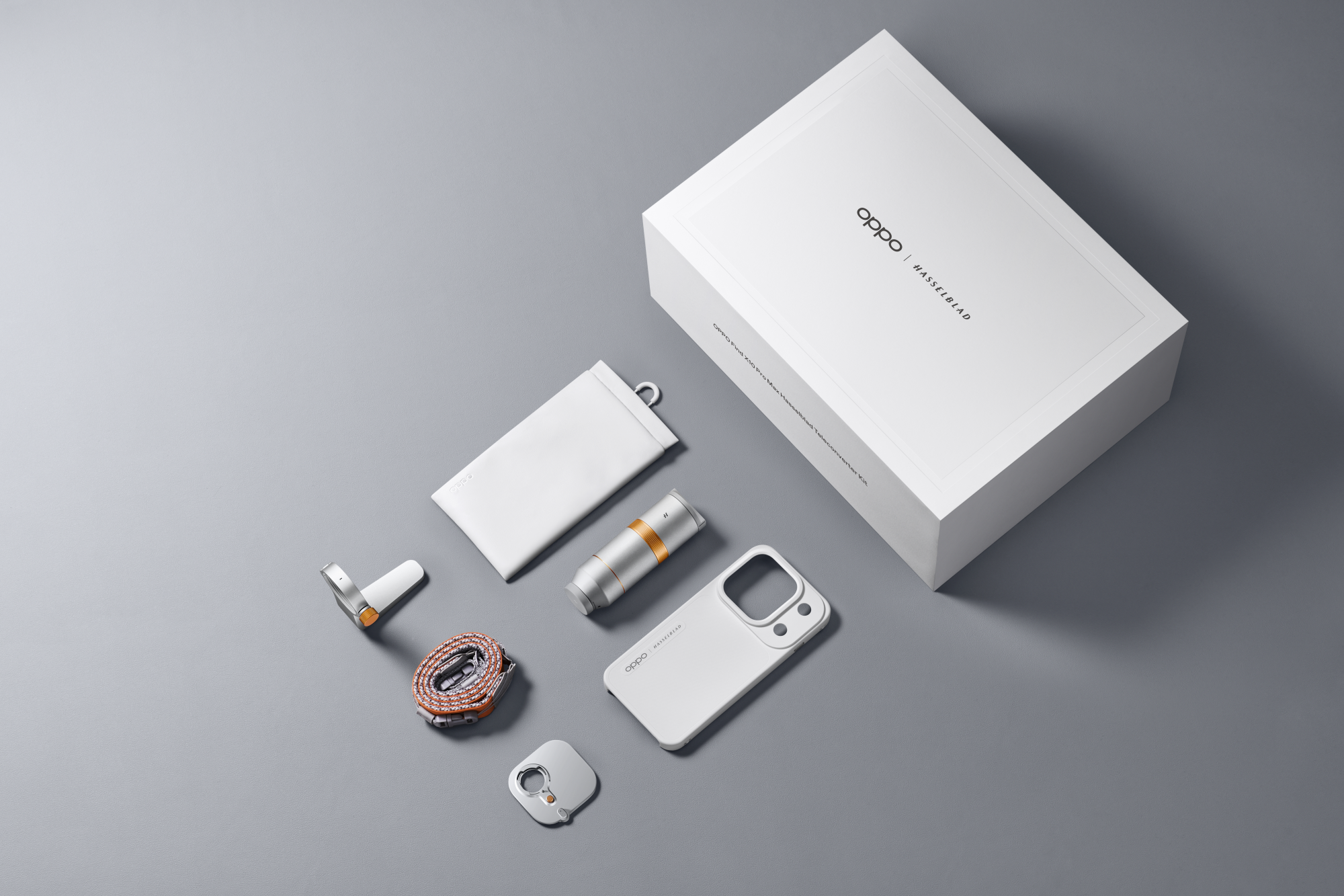Zestaw aparatów Oppo Find X7 Ultra Hasselblad z pudełkiem, etui, telekonwerterem, obudową i paskiem na szarym tle.