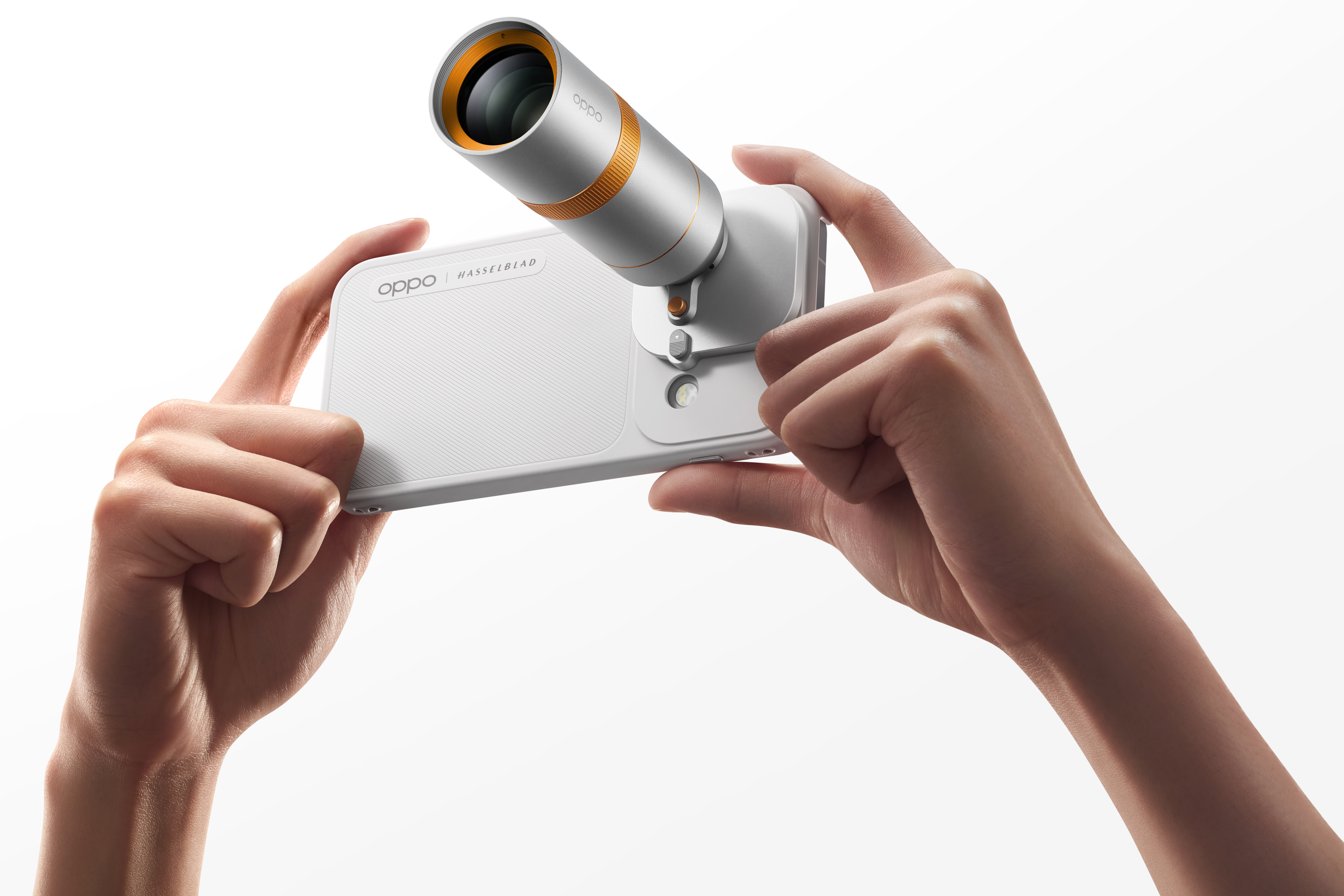 Ręce trzymające biały smartfon Oppo z dużym, dołączonym obiektywem tele.