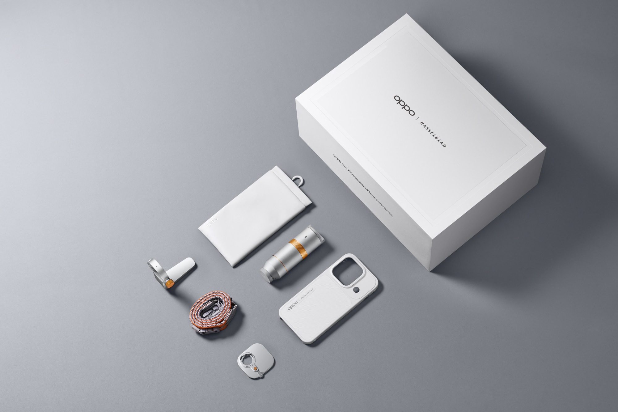 Zestaw konwertera teleobiektywu Oppo Find X10 Hasselblad z białym pudełkiem i akcesoriami na szarym tle.