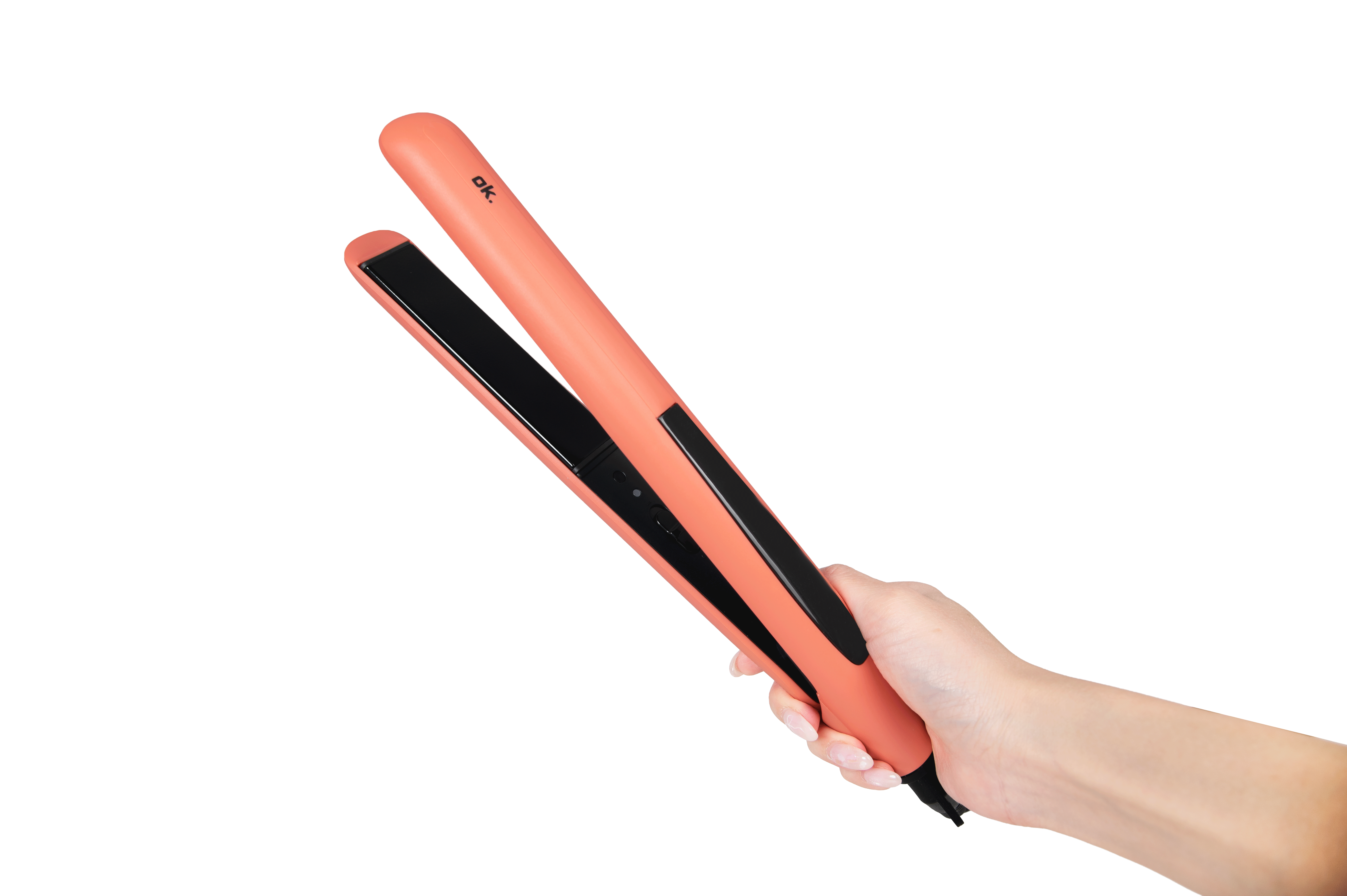 Una mano sostiene una plancha de pelo moderna de color salmón sobre un fondo negro.