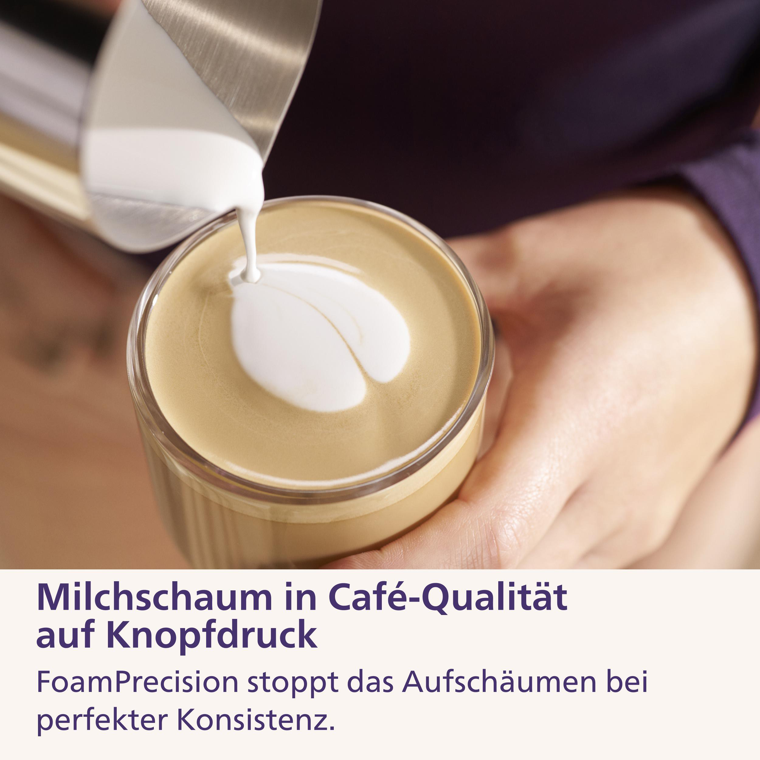 Milchschaum wird in eine Tasse Kaffee gegossen, um ein Herzmuster zu bilden.