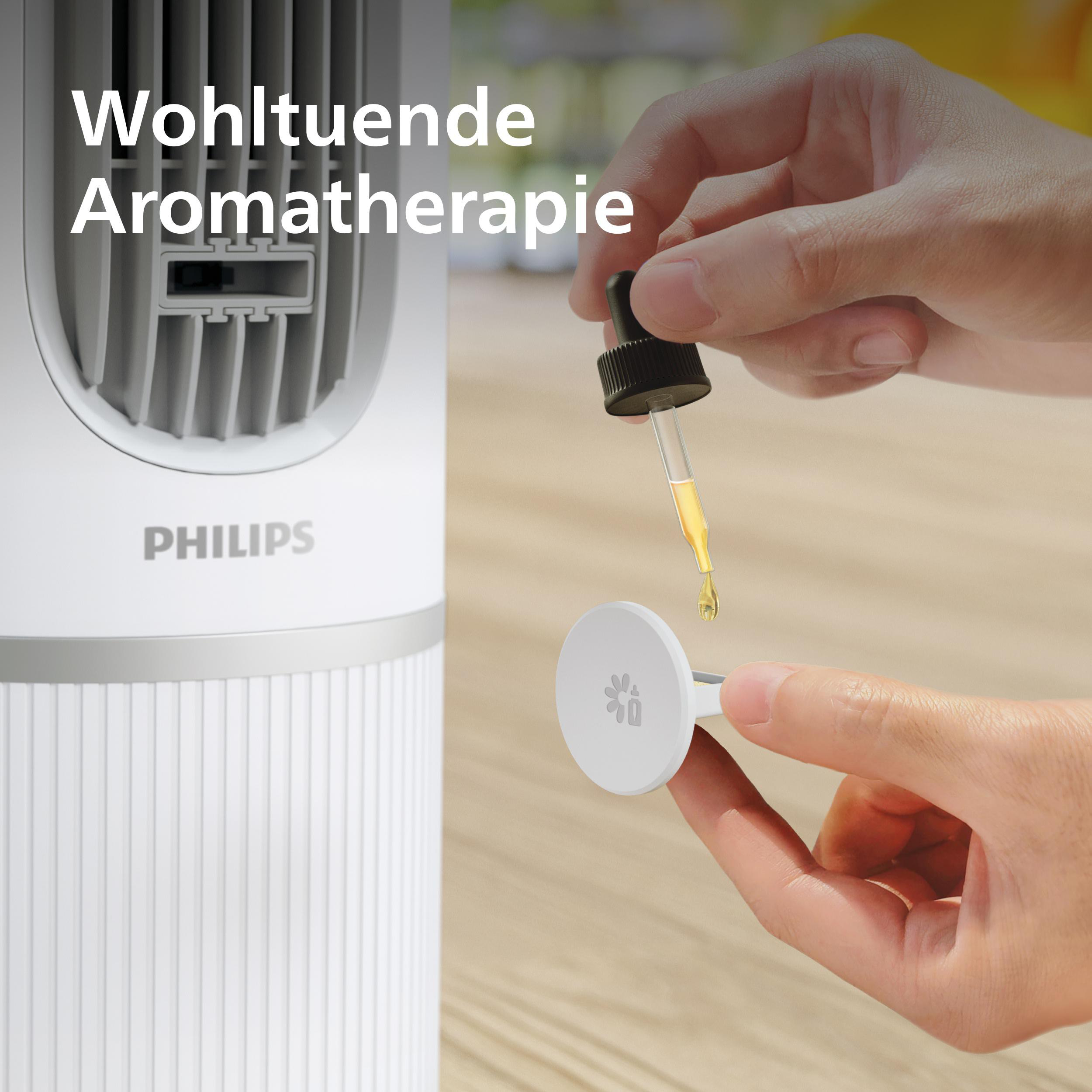 Eine Hand tropft Öl auf ein Philips Aromakissen, mit deutschem Text auf dem Bildschirm.