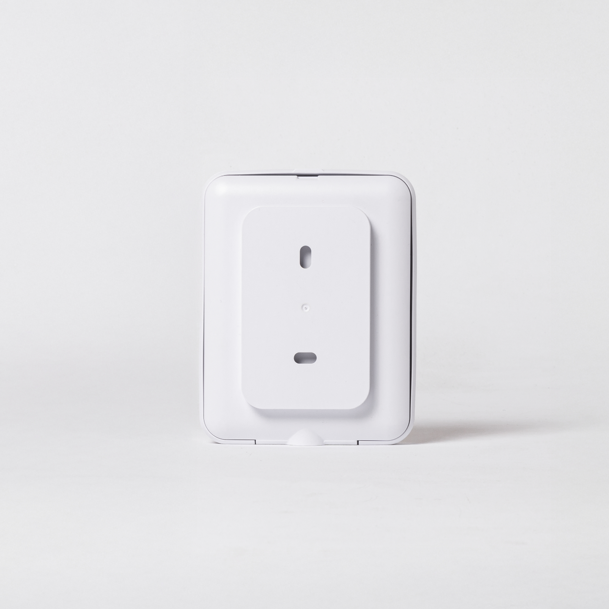 Ein weißes, rechteckiges elektronisches Gerät mit einer vertikalen Montageplatte auf der Vorderseite vor weißem Hintergrund.