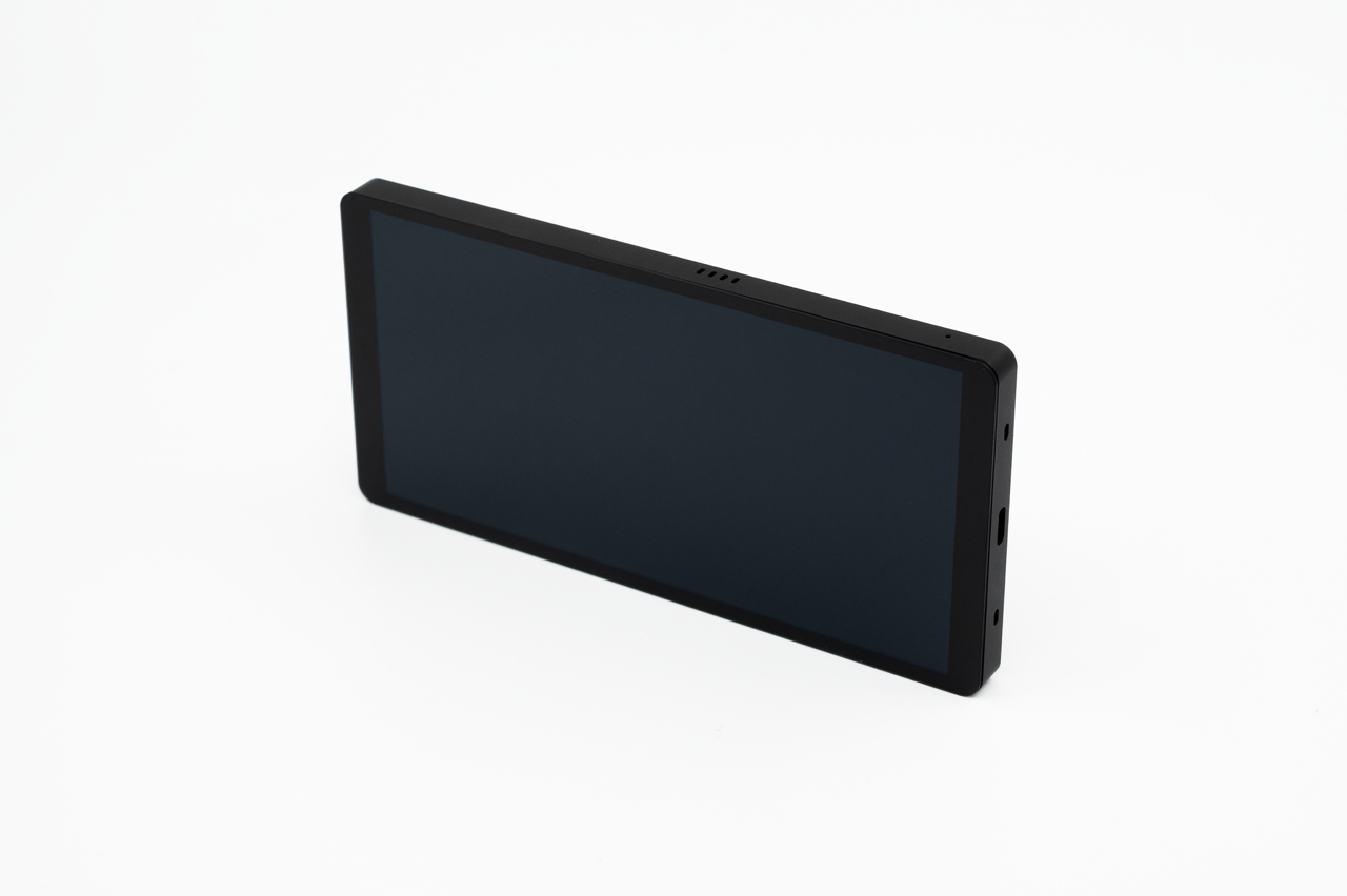 Ein schwarzes Smartphone liegt angewinkelt auf einem rein weißen Hintergrund.