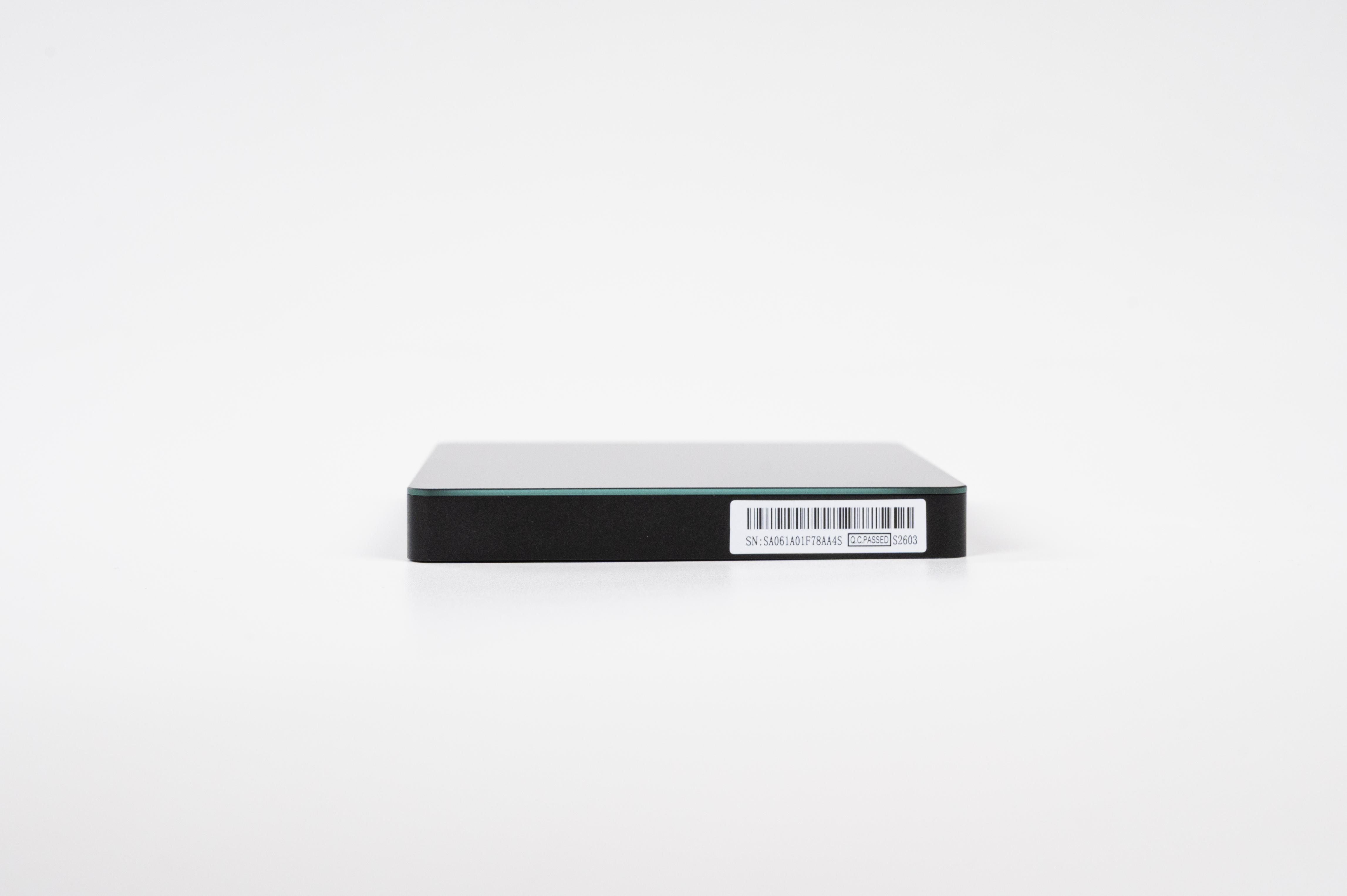 Ein flaches, schwarzes elektronisches Gerät mit einem Barcode-Aufkleber auf der Vorderseite vor einem weißen Hintergrund.
