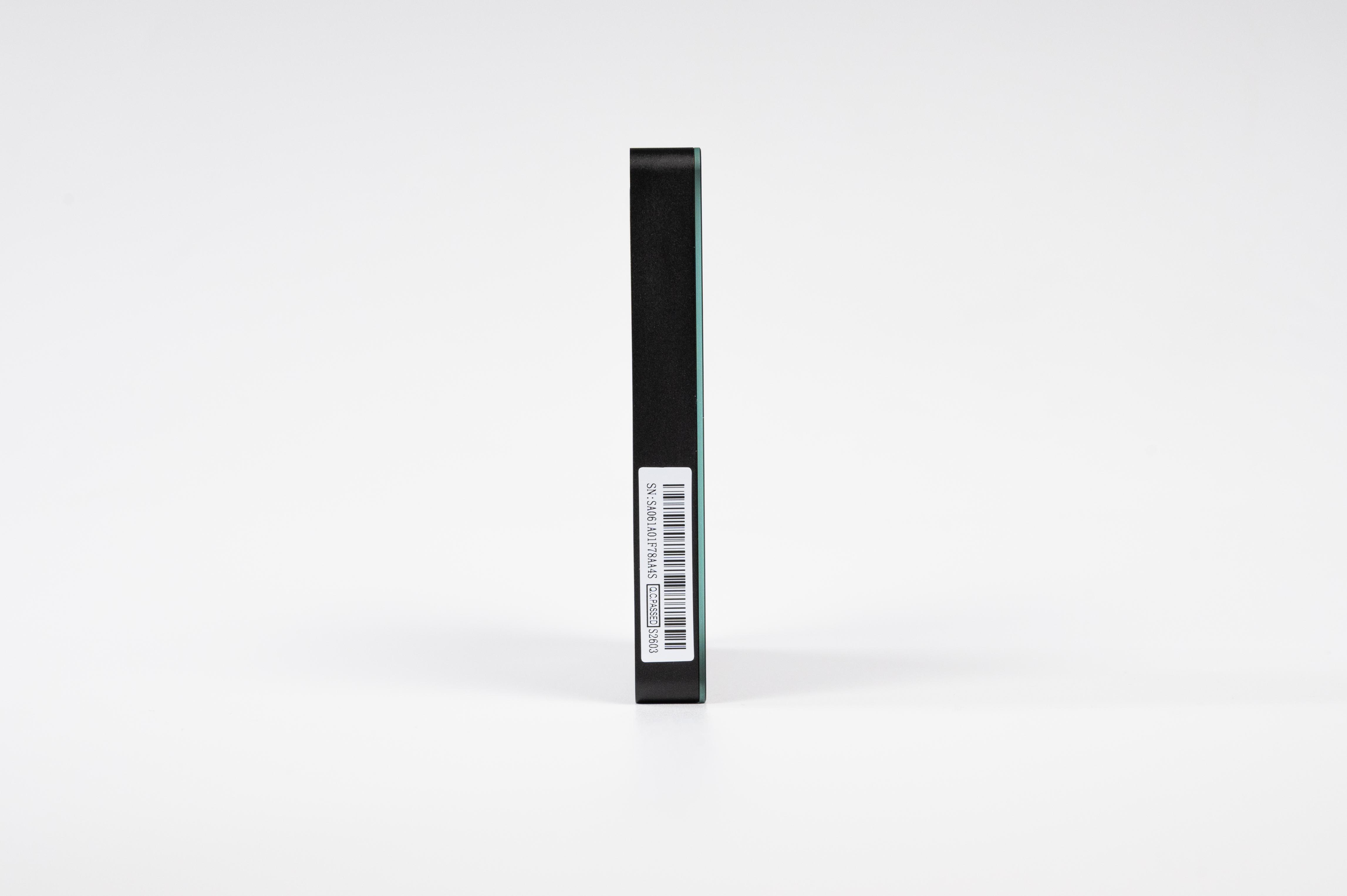 Ein schwarzes elektronisches Gerät mit einem Barcode-Sticker steht auf einer weißen Oberfläche.