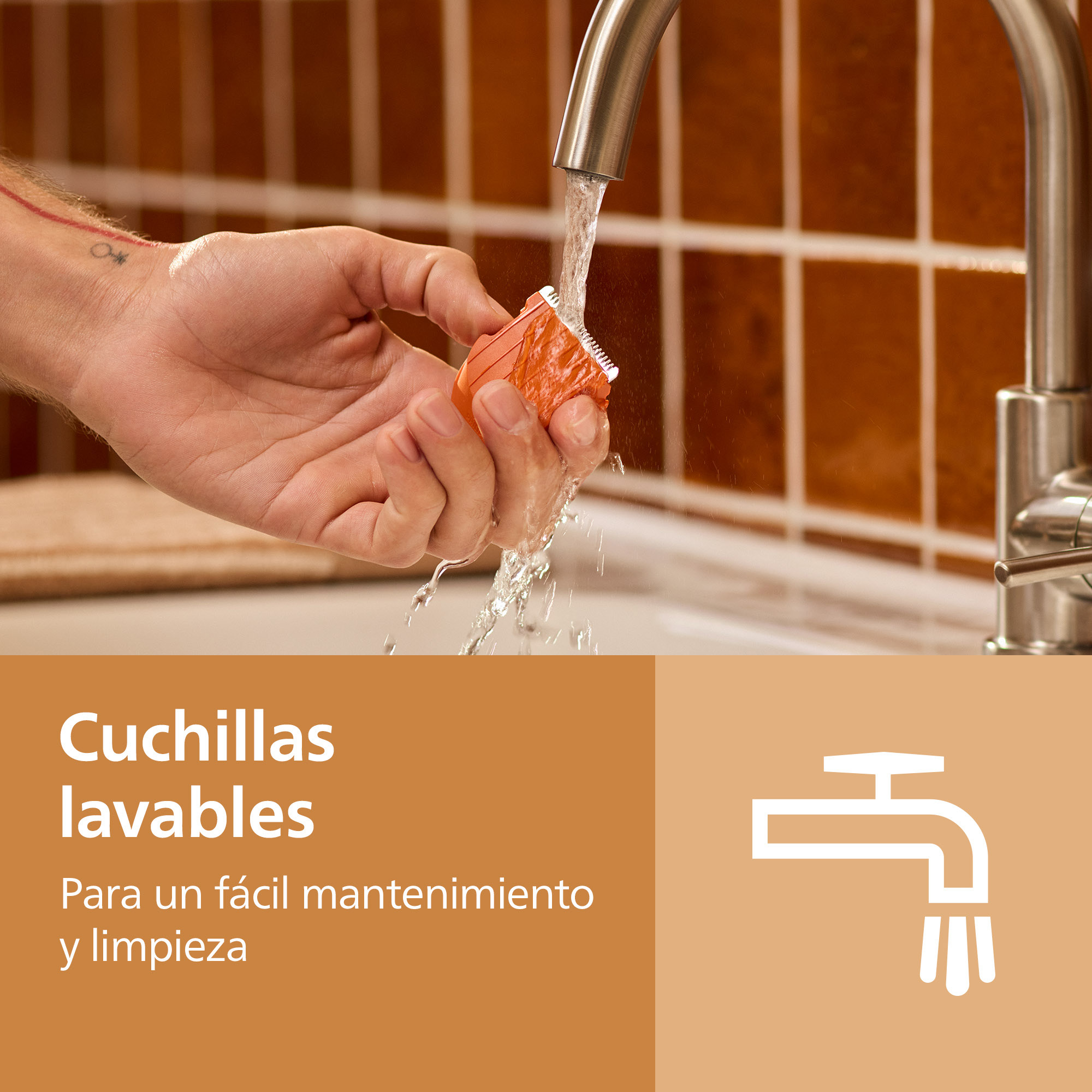 Una mano lava un accesorio de afeitadora naranja bajo el agua corriente frente a azulejos marrones.