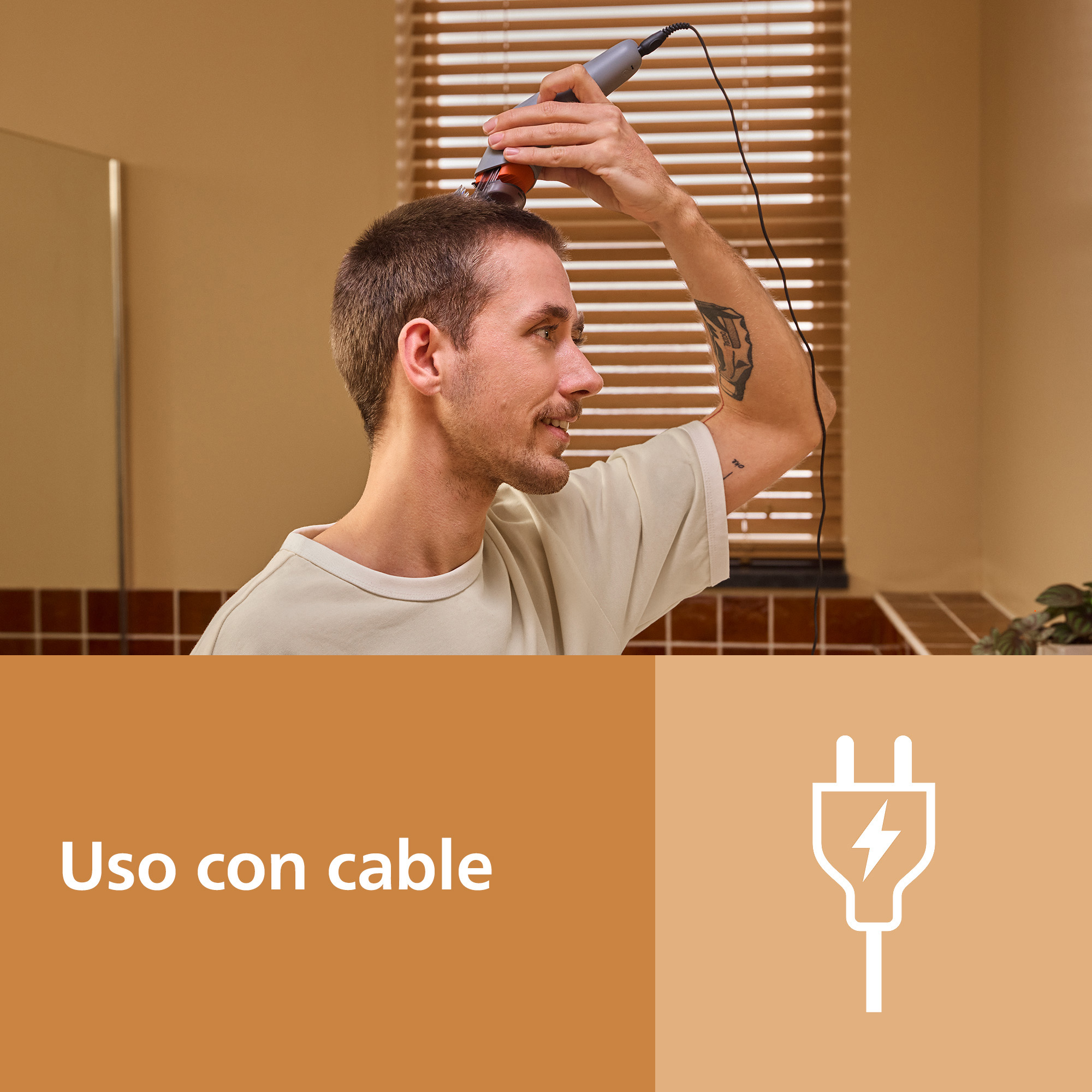 Un hombre se corta el pelo con una maquinilla con cable.