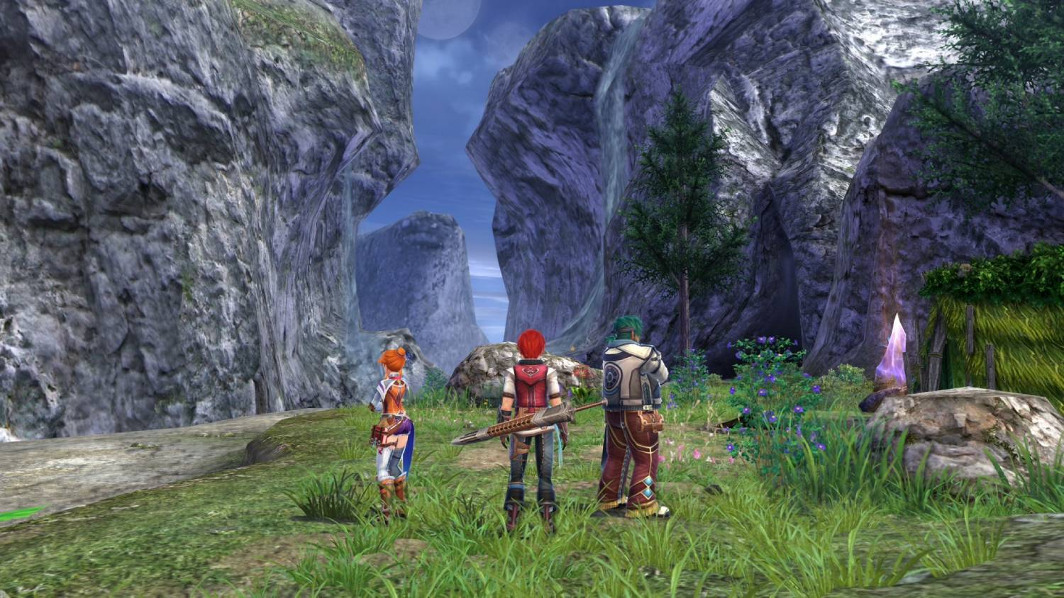 Tres personajes se encuentran en un paisaje montañoso frente a enormes acantilados grises.