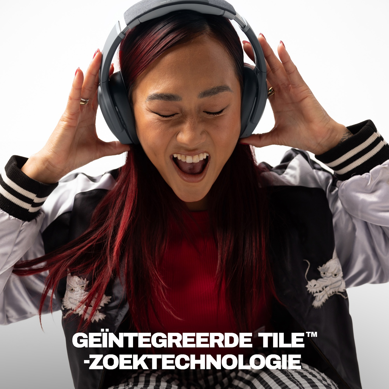 Een vrouw met rood haar en een koptelefoon glimlacht vrolijk terwijl ze hem opzet.