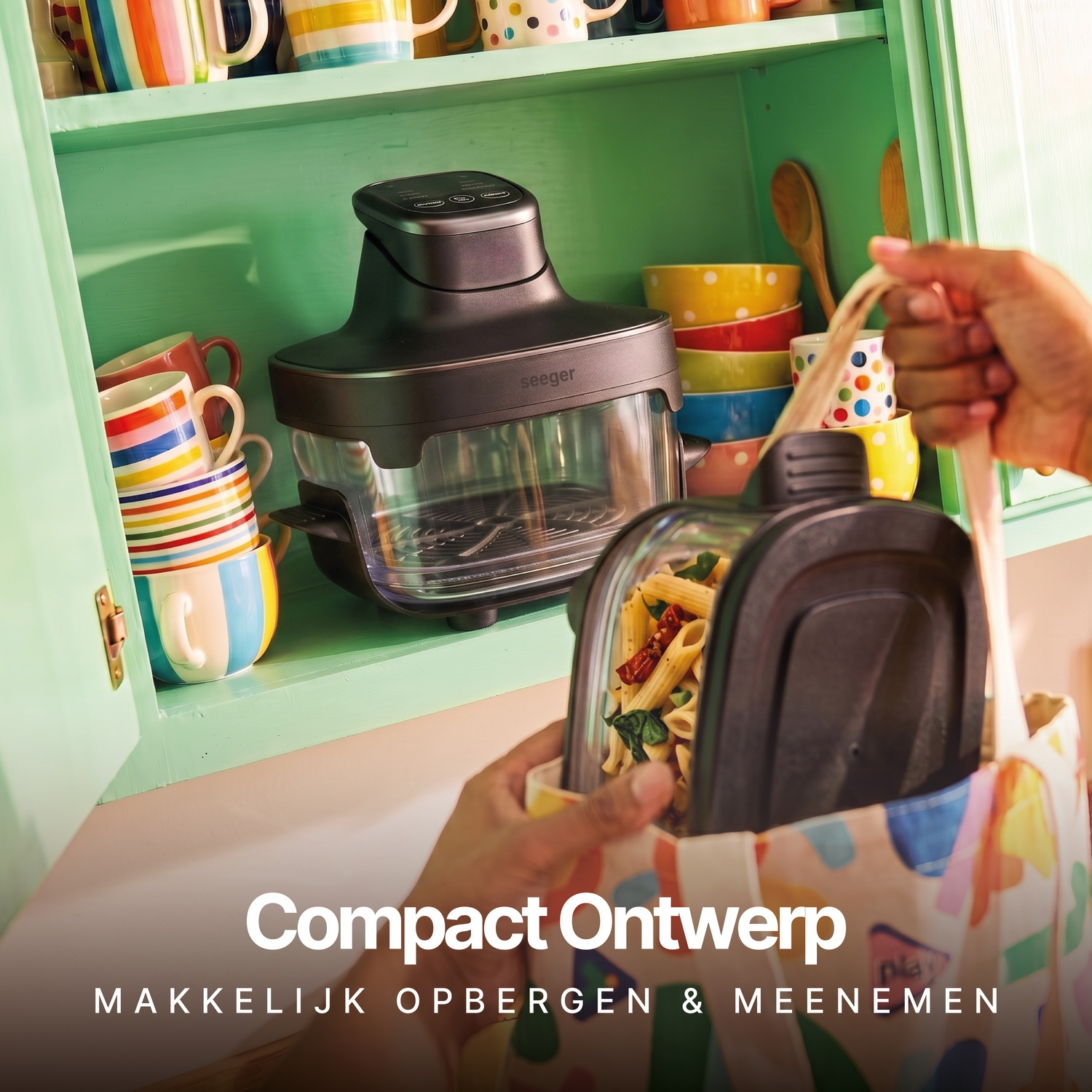 Hand haalt pastabak uit kleurrijke tas, met keukenkast en apparaat op de achtergrond.