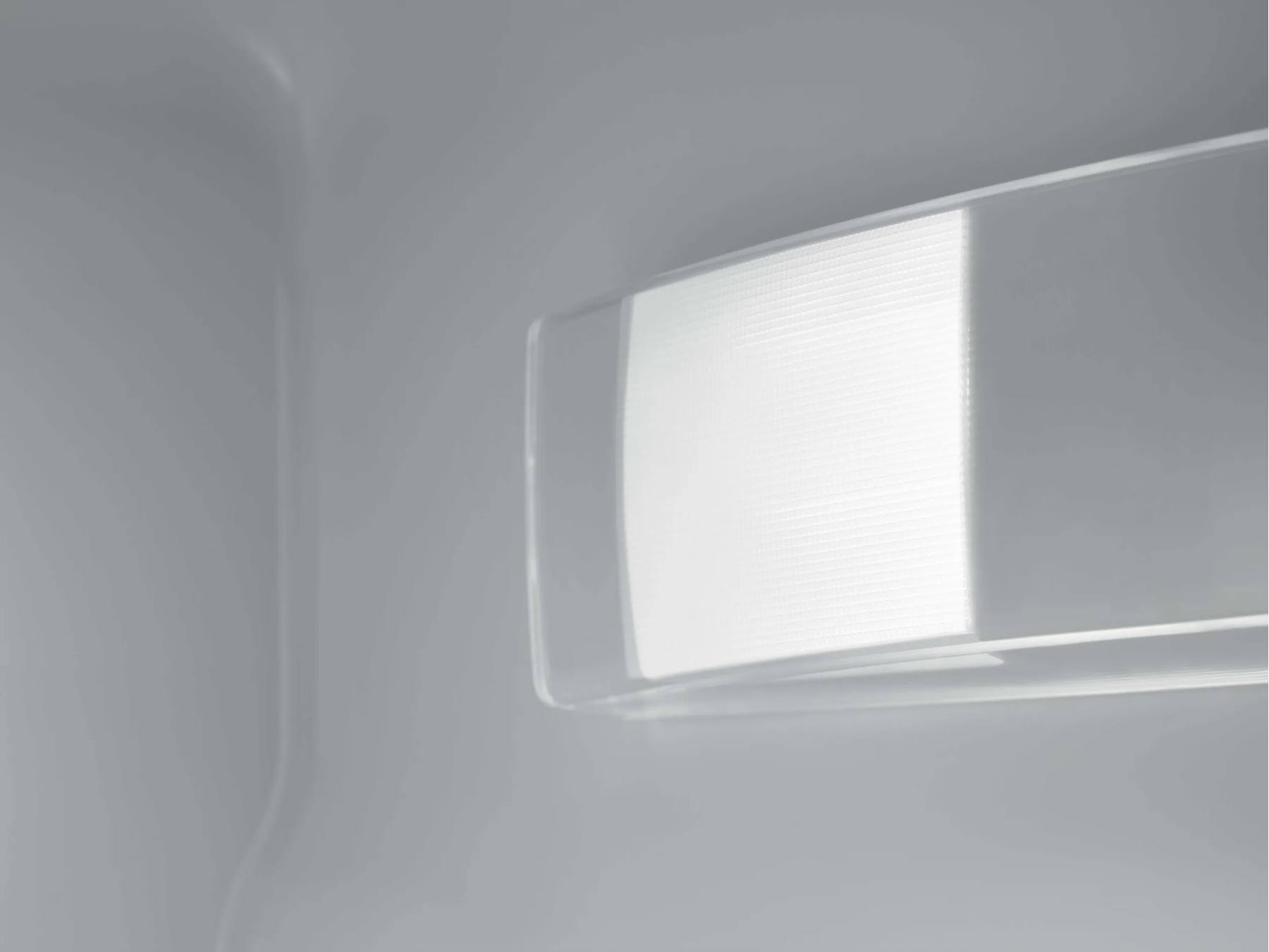 Una luz LED brillante está montada en la pared interior gris de un refrigerador.