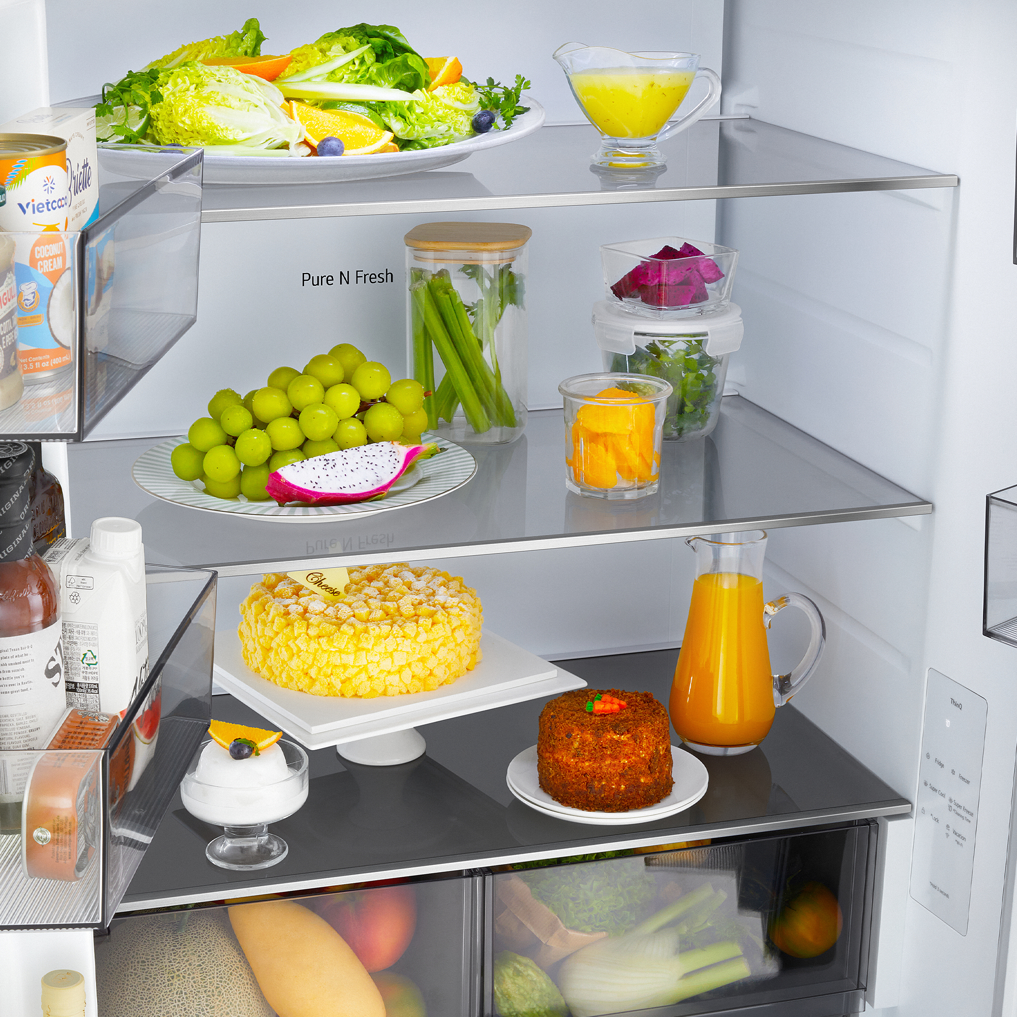 Un refrigerador bien abastecido con fruta fresca, ensalada, pastel y bebidas.