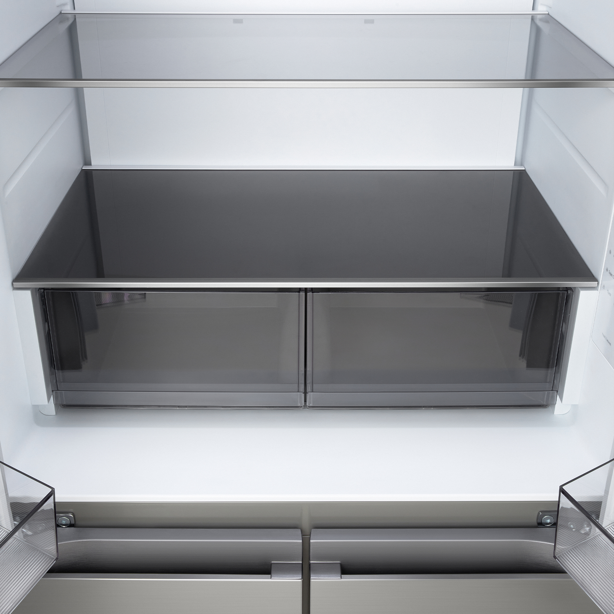 Interior vacío y limpio de un frigorífico moderno con estantes de cristal y cajones.