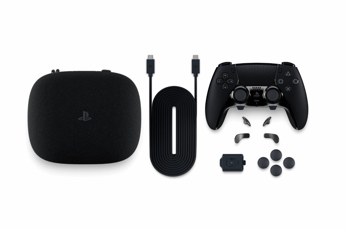 Czarny kontroler PlayStation z etui, kablem USB i akcesoriami na białym tle.