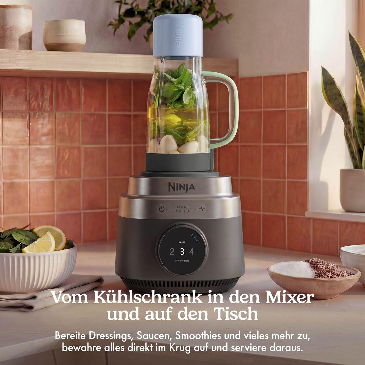 Ein grauer Ninja Mixer steht auf der Küchentheke vor einer rot gefliesten Wand.