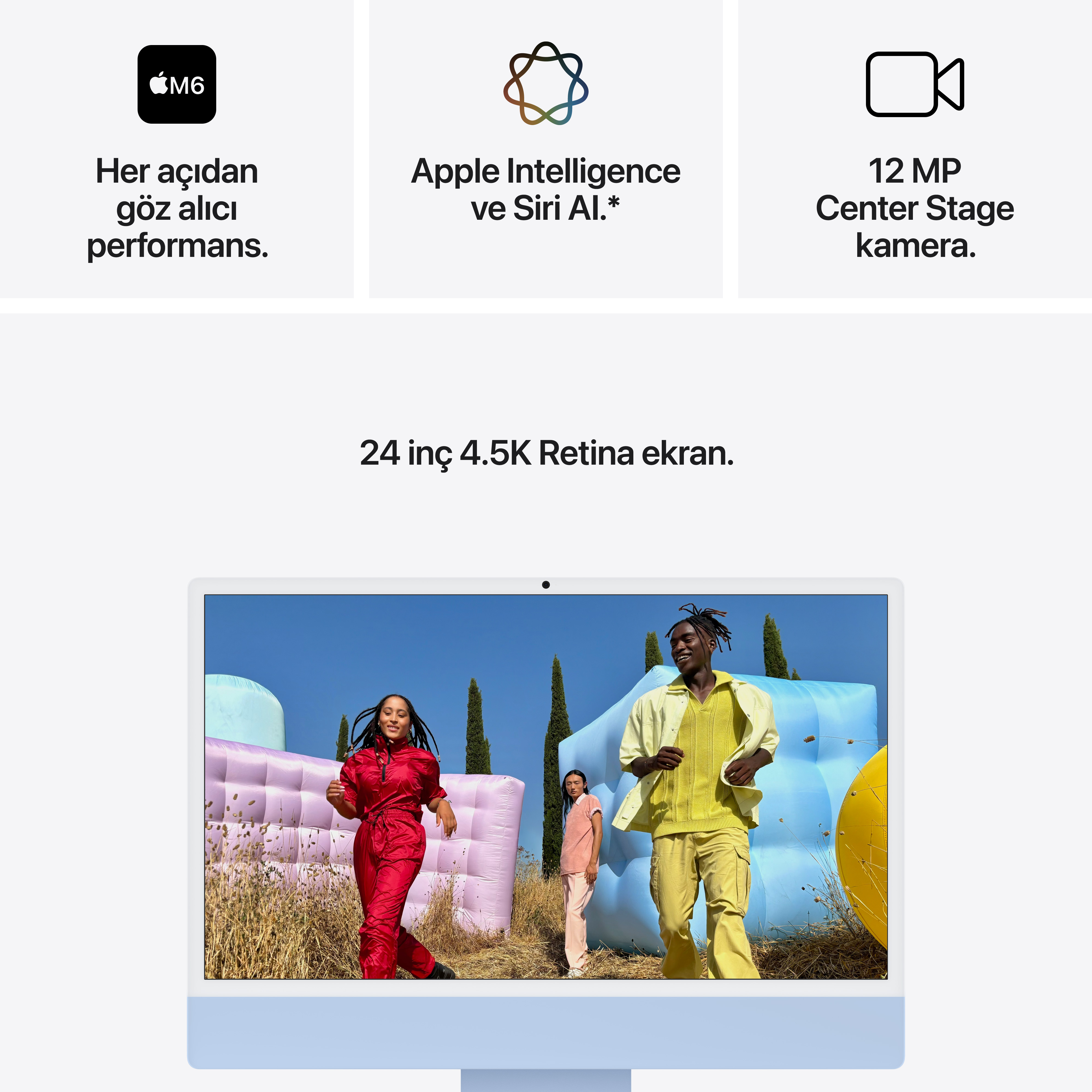 Şişme yapıların bulunduğu güneşli bir dış mekanda yürüyen üç kişiyi gösteren bir iMac.