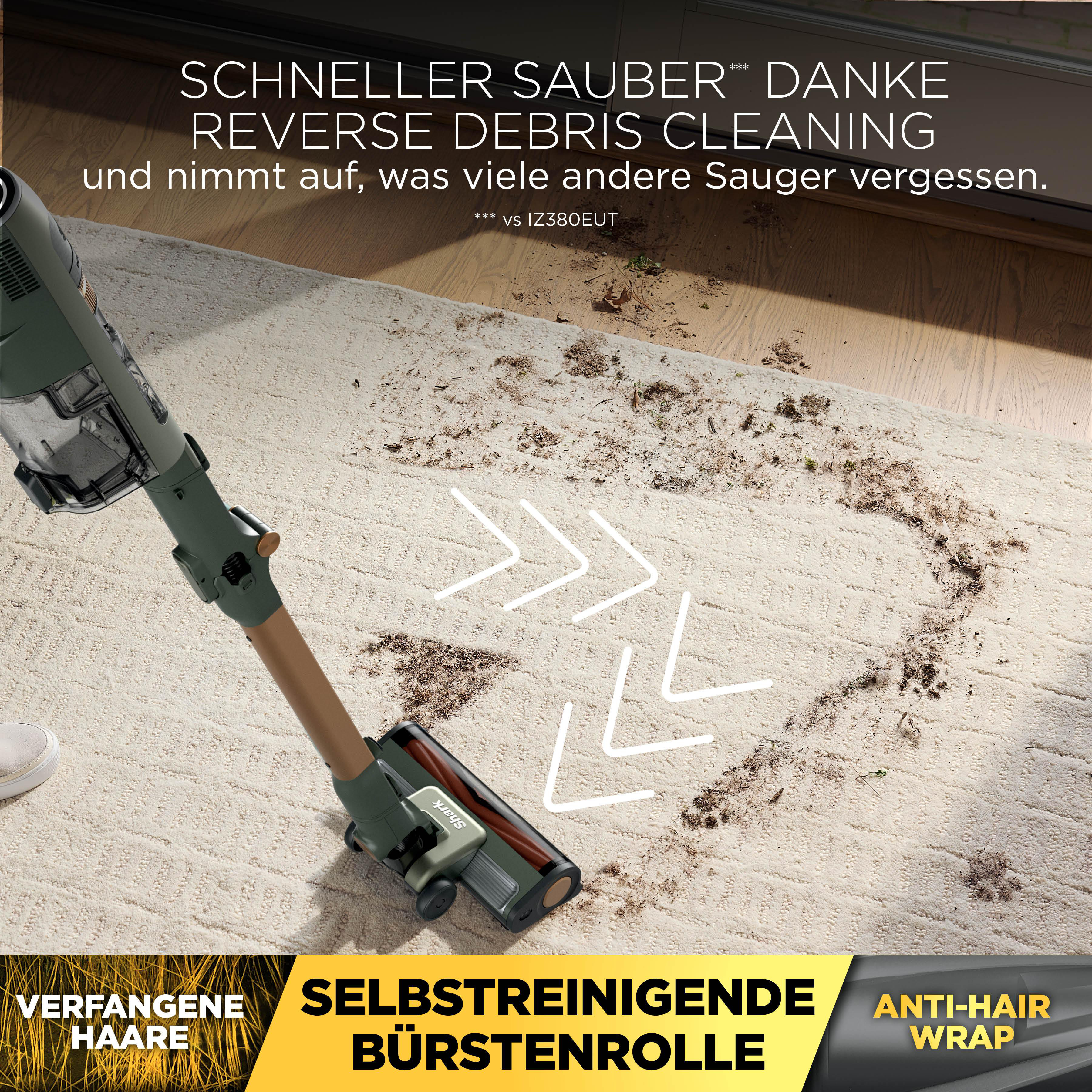 Ein grüner Akkusauger reinigt einen hellen Teppich mit Schmutz.