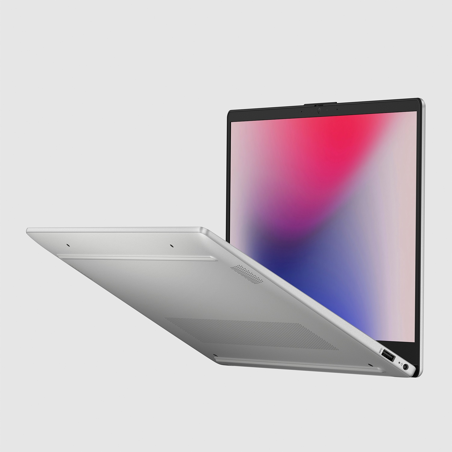 Een zilveren laptop is licht geopend tegen een lichte achtergrond en toont een kleurrijk scherm.