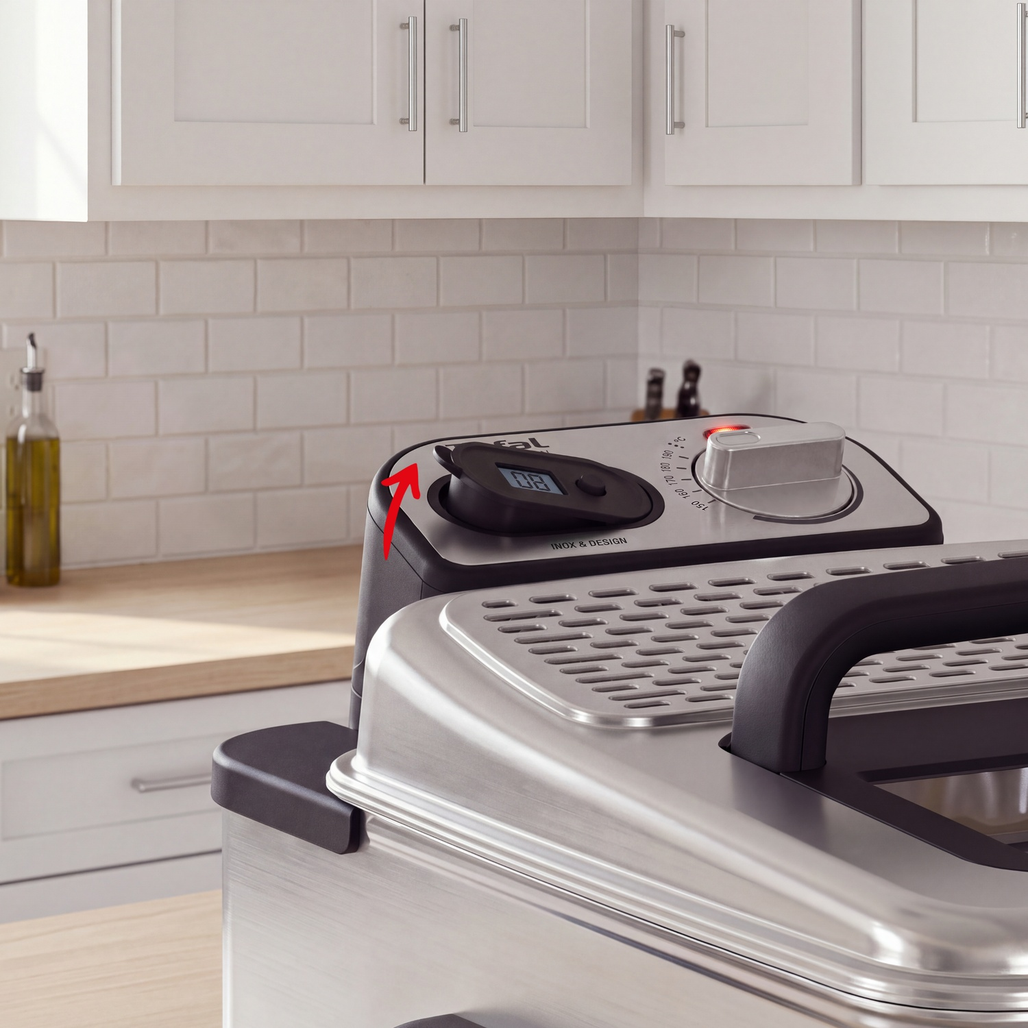 Une friteuse en acier inoxydable avec une flèche rouge pointant vers le minuteur.