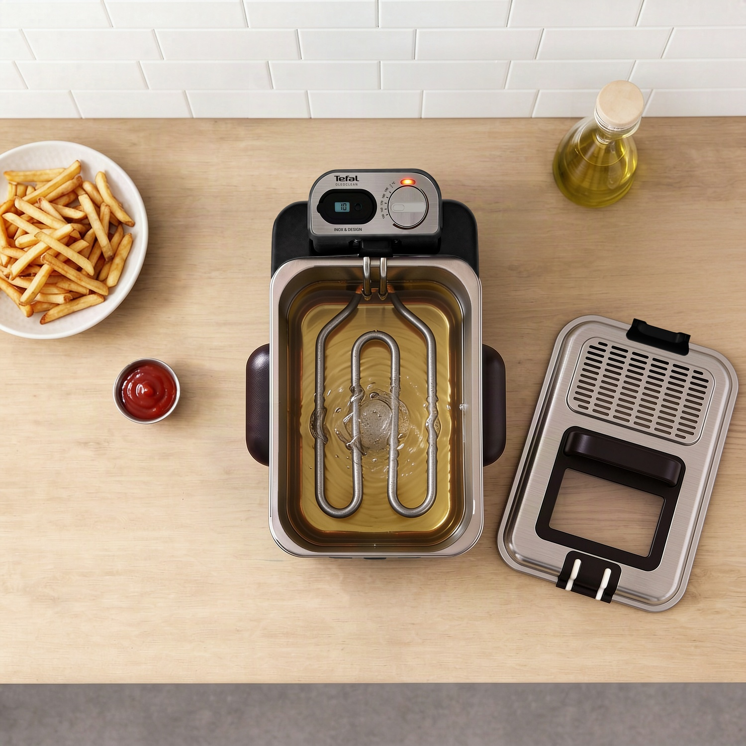 Une friteuse Tefal sur un comptoir en bois avec un bol de frites, du ketchup, un couvercle et une bouteille d'huile.