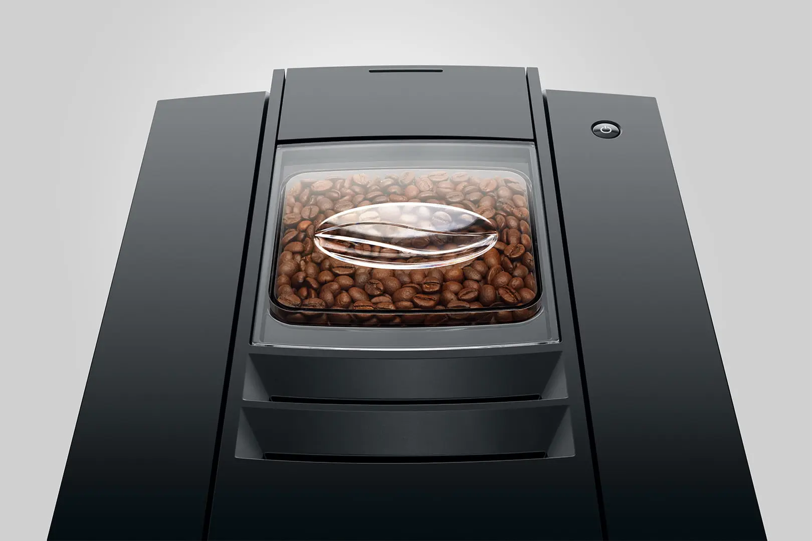 Cafetera negra con depósito de granos relleno y tapa transparente con forma de grano de café.