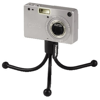 Silver digital camera mounted on a flexible black tripod.
