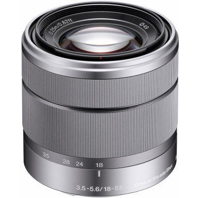 A silver camera lens with focus rings and number markings.