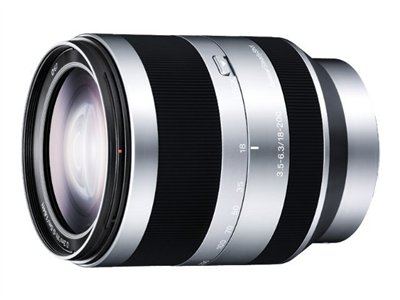 Silver and black camera lens, labeled 18-200mm. Glass elements visible.