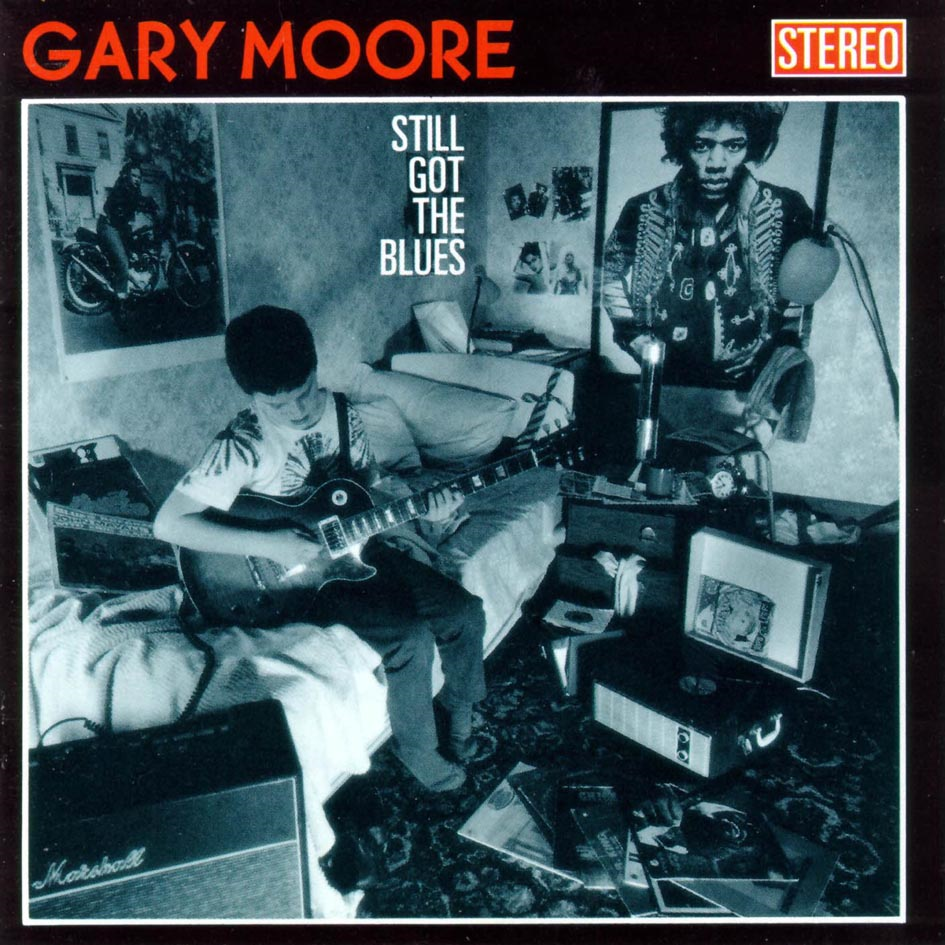 Gary Moore "Still Got The Blues" című albumának borítója. Egy férfi gitározik egy szobában, fotókkal és poszterrel.