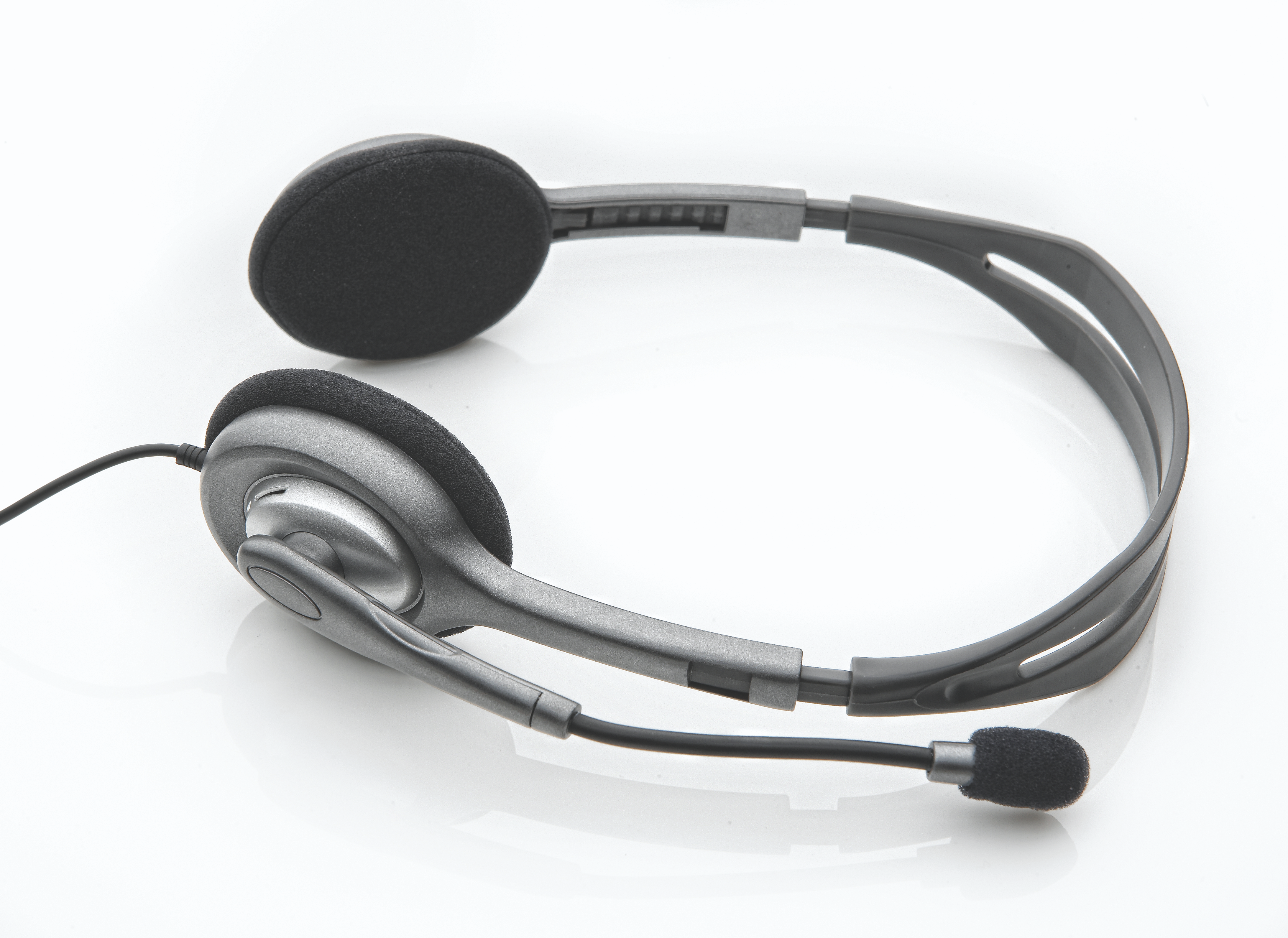 Headset op witte achtergrond. Het heeft een microfoon, twee oordopjes met zwarte kussentjes en een grijs frame.
