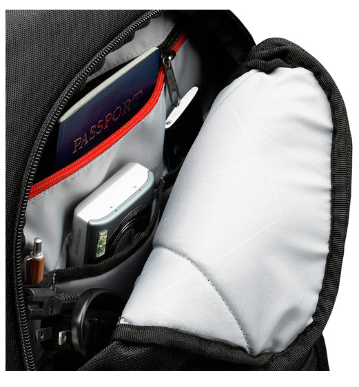 Binnenkant van een zwarte rugzak. Zichtbaar: paspoort, camera, pen, oplader en een ritsvak. Grijze voering.