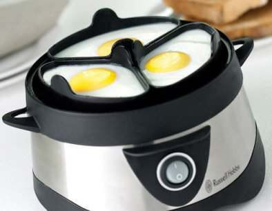 Egg boiler machine. Shiny silver. Three eggs cooking in the clear container. White background.