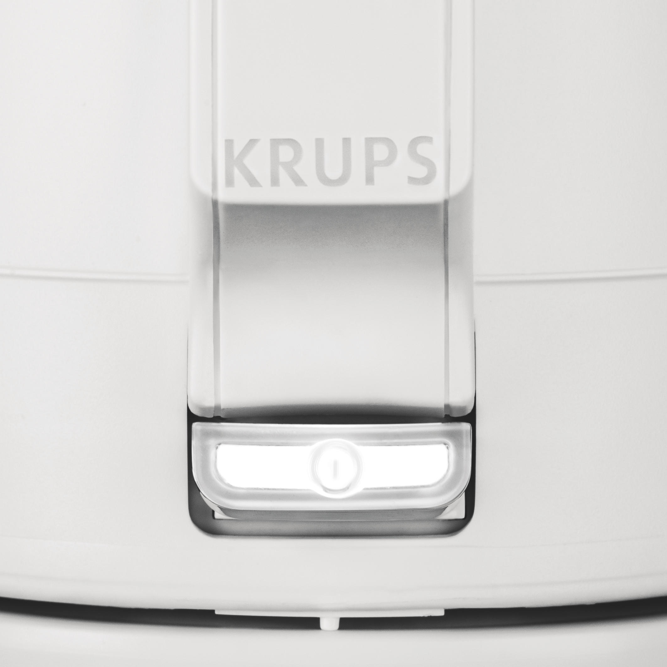Nahaufnahme eines weißen Geräts mit dem Wort KRUPS. Unten leuchtet ein Licht.
