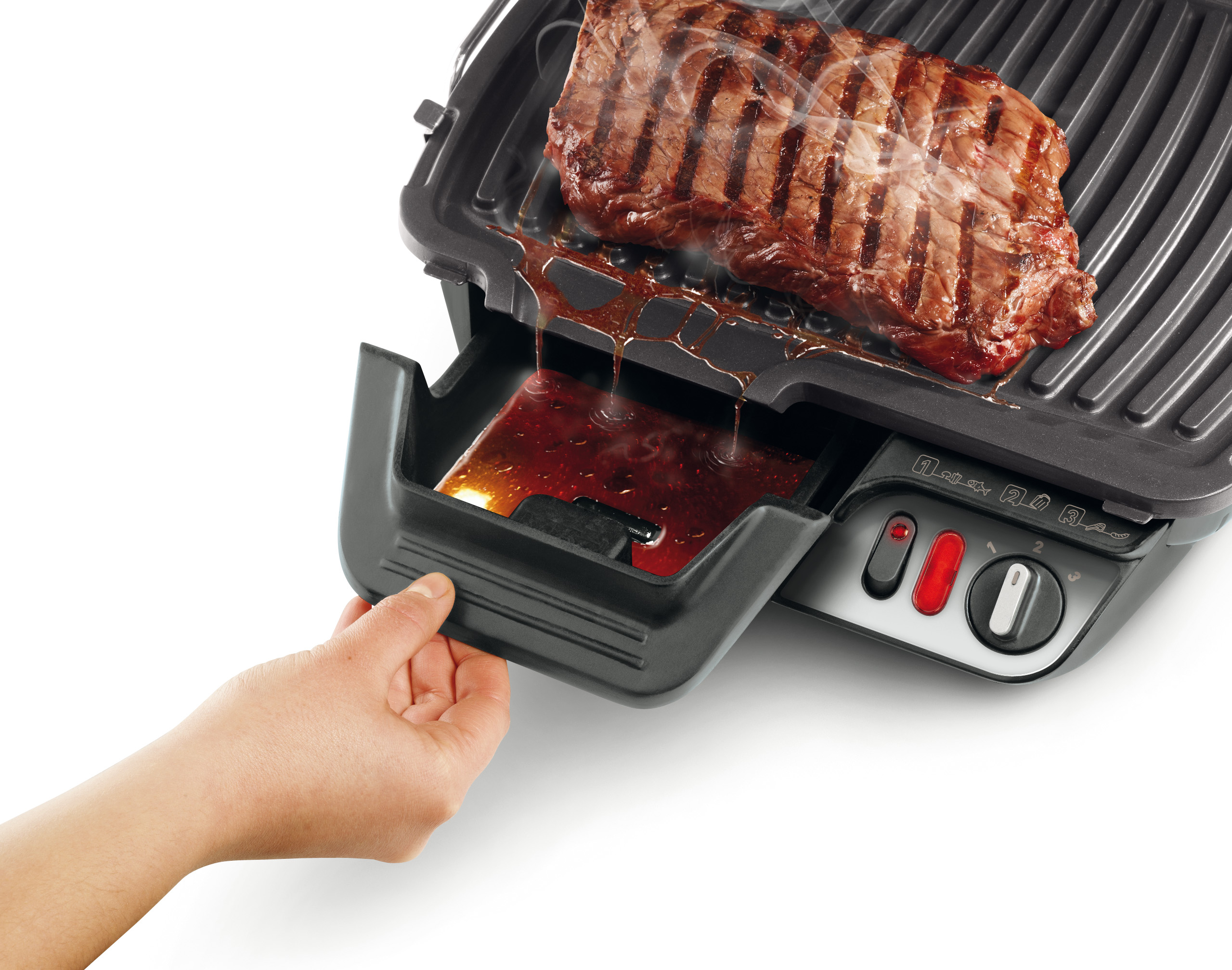 Steak grillé sur un grill. Des jus dégoulinent dans un plateau. Une main tire le plateau.