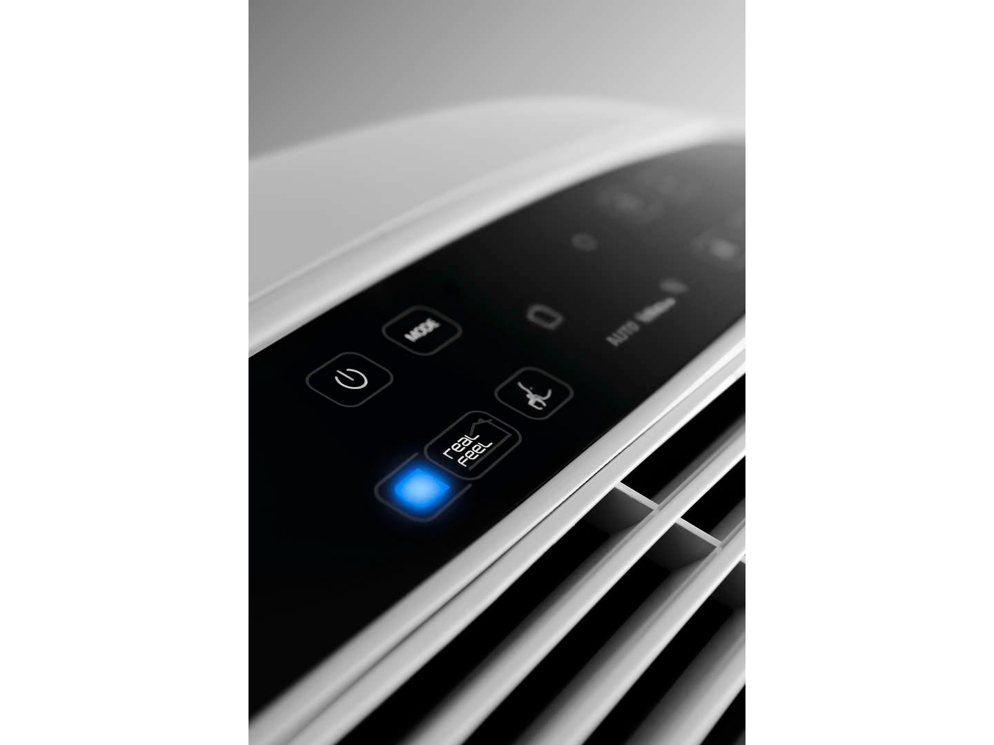 Close up of a white air purifier's control panel, with lit blue button.