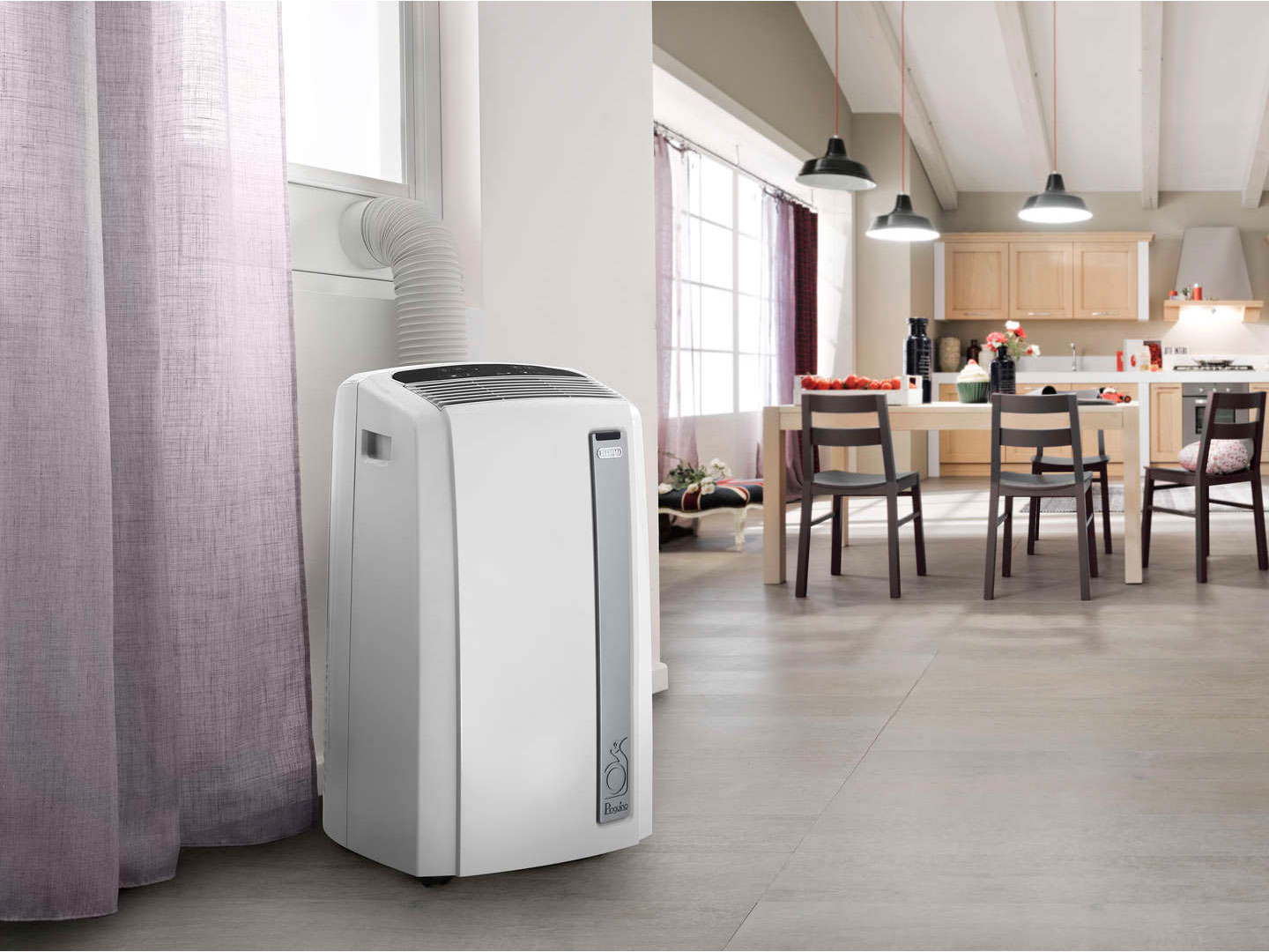 A white portable air conditioner in a modern living room. Kitchen and dining area in the background.
