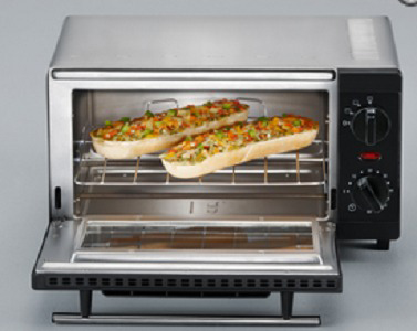 A toaster oven with two pieces of bread with toppings. The oven is open.