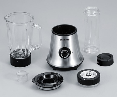 Pièces de mixeur. Une base de mixeur métallique, un pichet en verre, un bocal, un couvercle et un ensemble de lames. Fond gris.