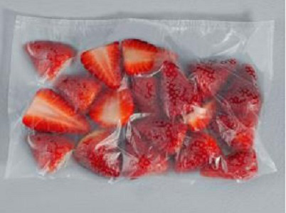 A clear plastic bag of sliced strawberries. Red fruit is visible.