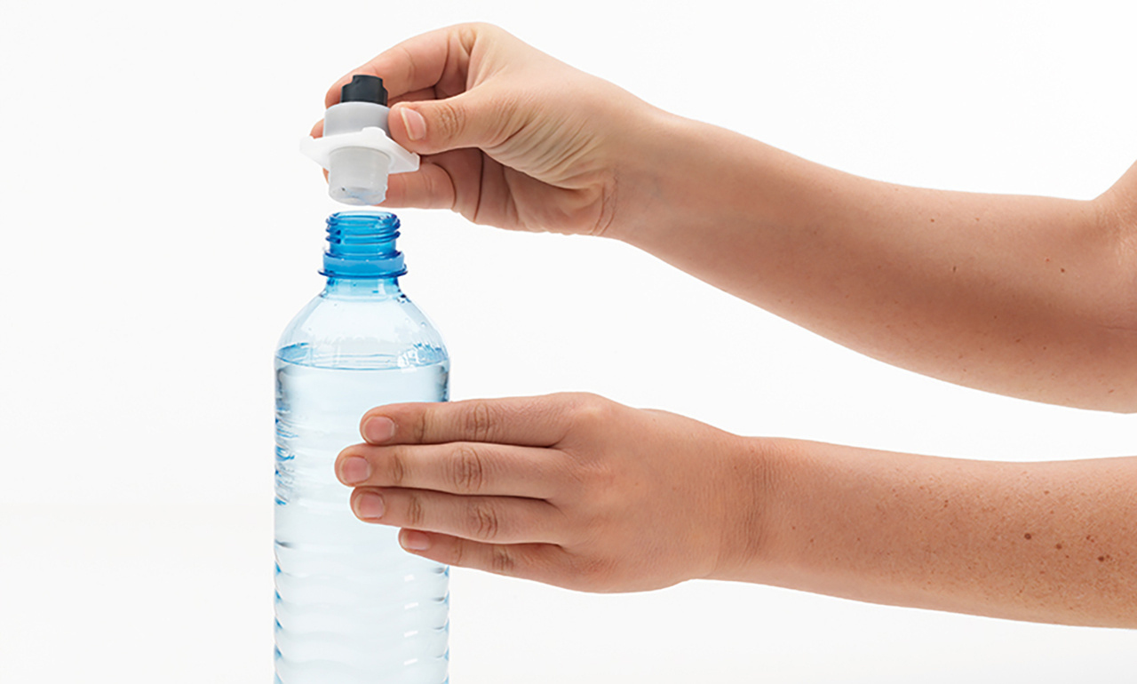 Hände öffnen eine Wasserflasche, entfernen die Kappe. Weißer Hintergrund.